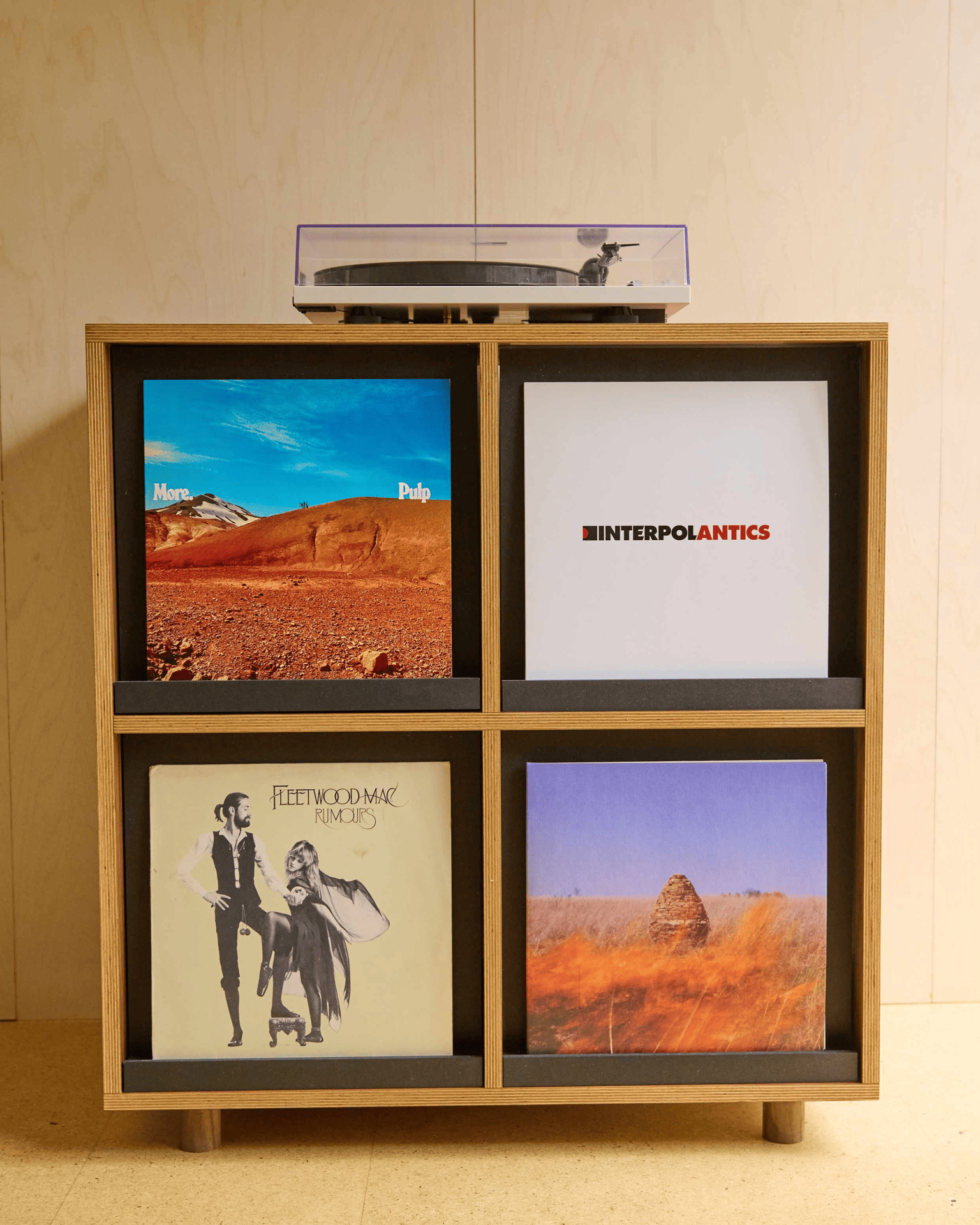 plywood record cabinet with four drawers. each drawer front has a unique record display shelf so you can display album covers like pieces of art and change them whenever. holds 200 records. solid walnut feet.