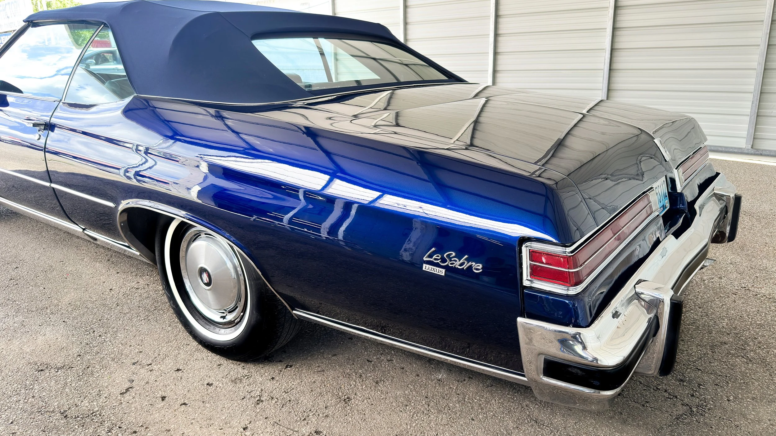 A vintage blue Cadillac Seville luxury convertible with a black soft top, convertible professionally detailed by LuxDream Detailing, Louisville, KY