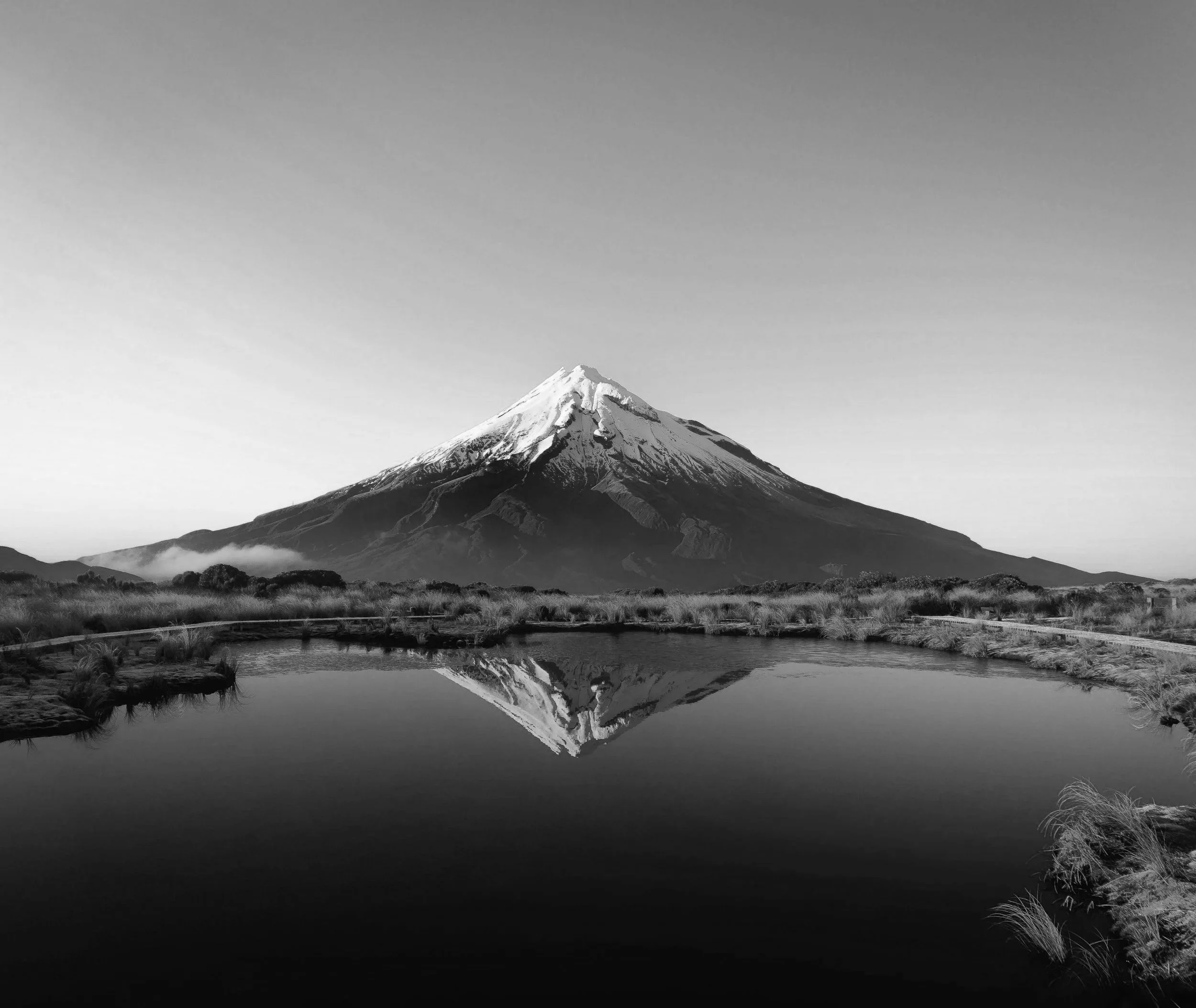 A volcano Mount Taranaki reflected in a pool of water