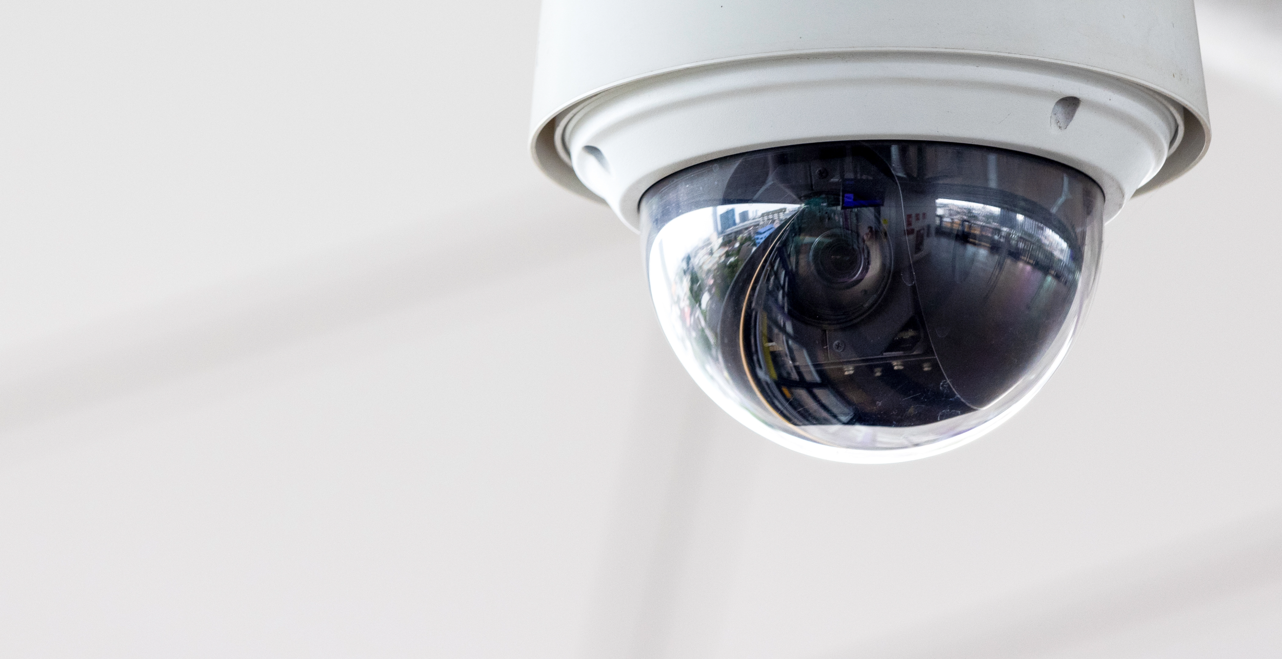 Close-up view of a security camera mounted on a ceiling.