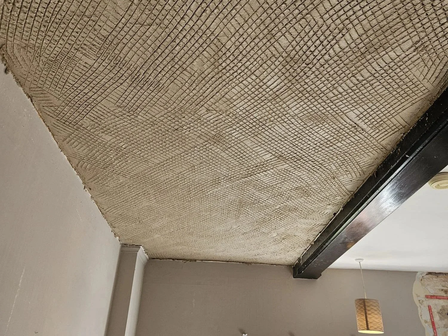 Ceiling with exposed wood lath, part of a renovation or construction process.