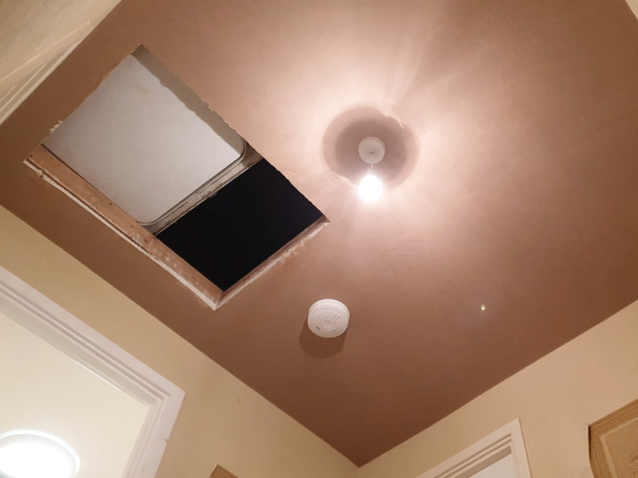 Ceiling with an opening where a vent cover was removed and a light fixture turned on.