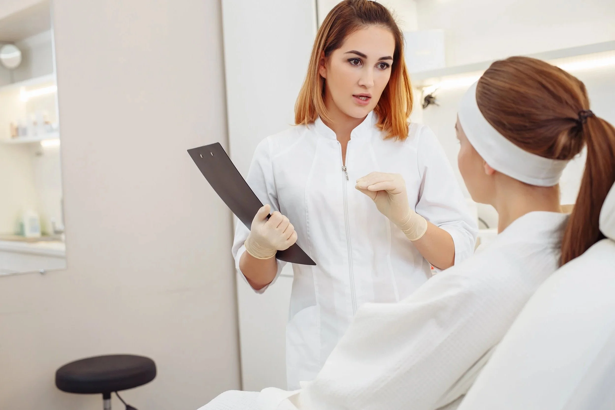 A healthcare professional explains a treatment plan to a patient in a clinical setting.