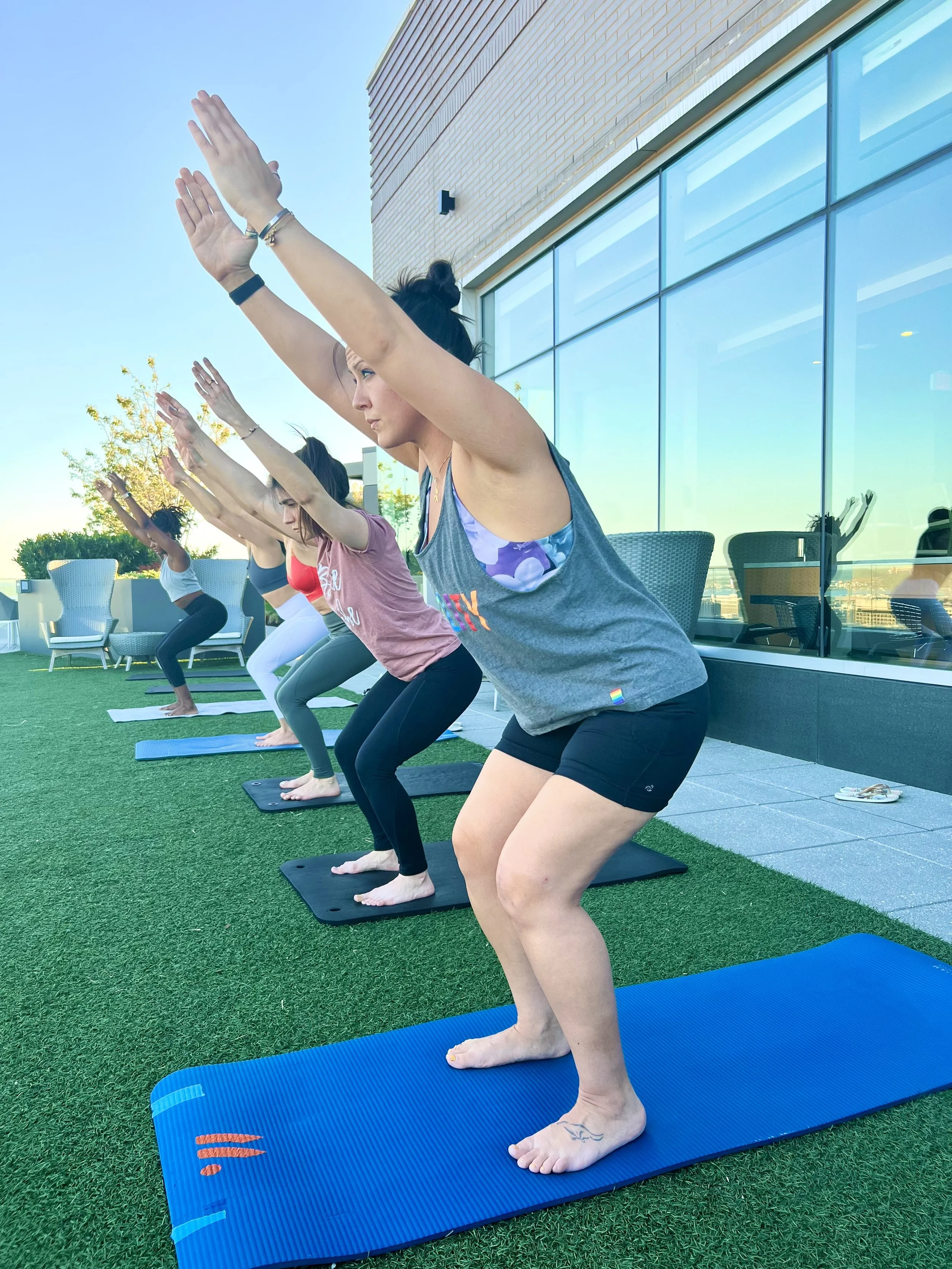 Women practicing yoga together outdoors during a community class.