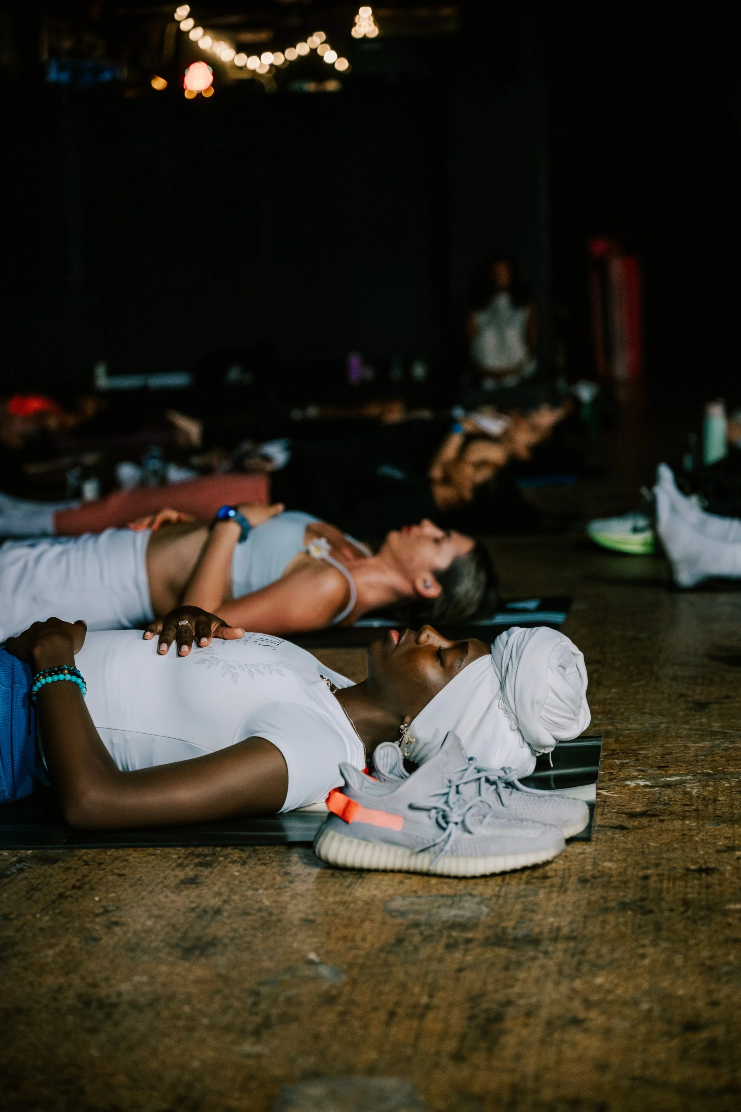 Participants resting on yoga mats during a guided breathwork and relaxation experience