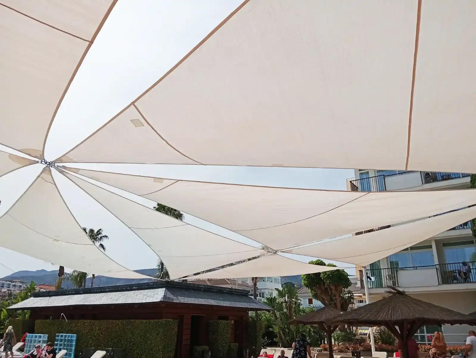 piscina de comunidad de propietarios con velas de sombra