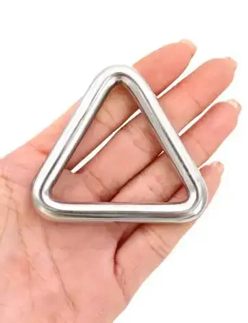 Una mano sostiene un objeto metálico en forma de triángulo con esquinas redondeadas.