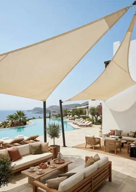 Hotel en Marbella con velas de sombra en la zona de la piscina, sillones de exterior y restaurante