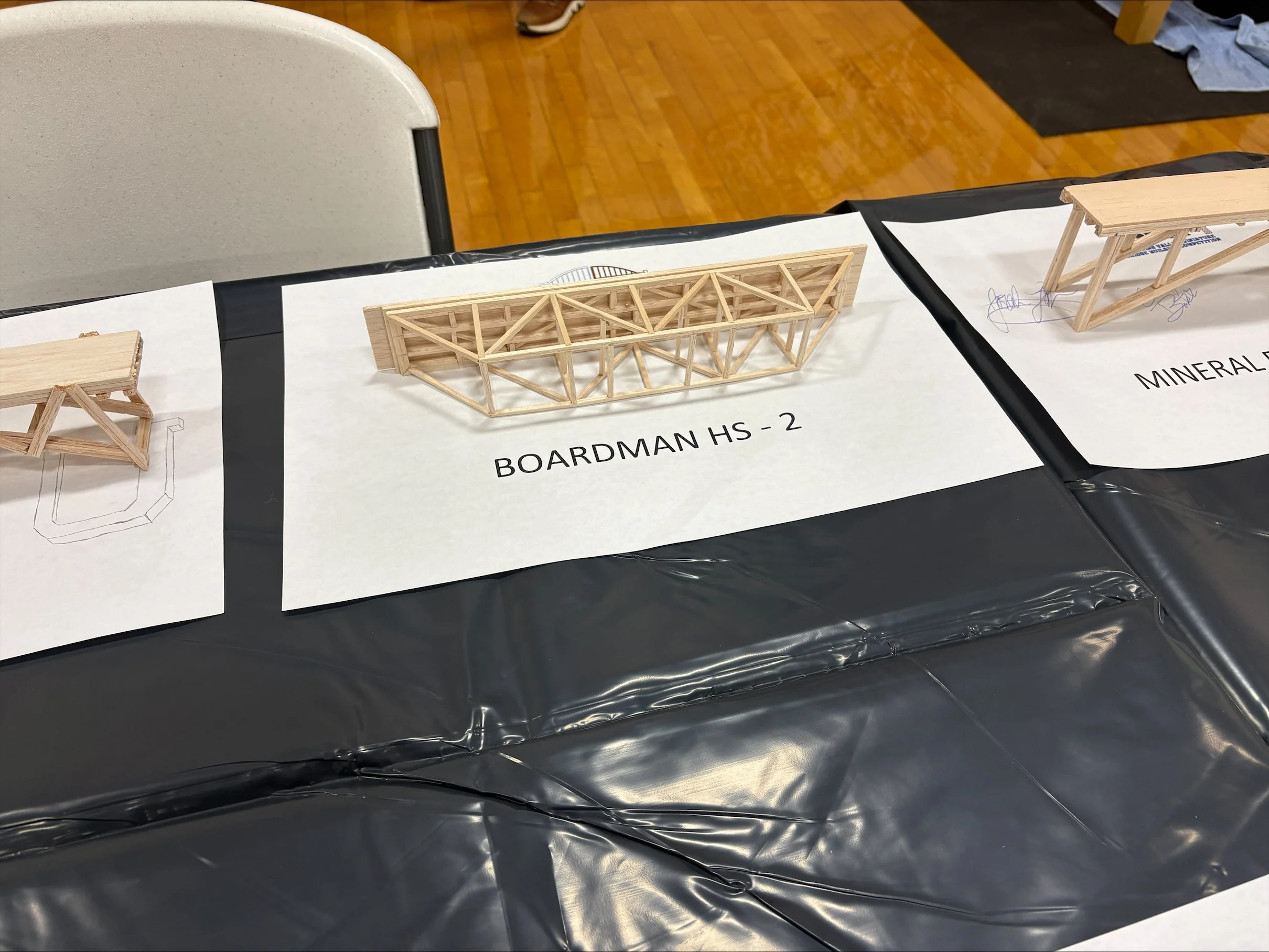 Display of architectural models made from wood with labels indicating 'BOARDMAN HS - 2' and 'MINERAL.'