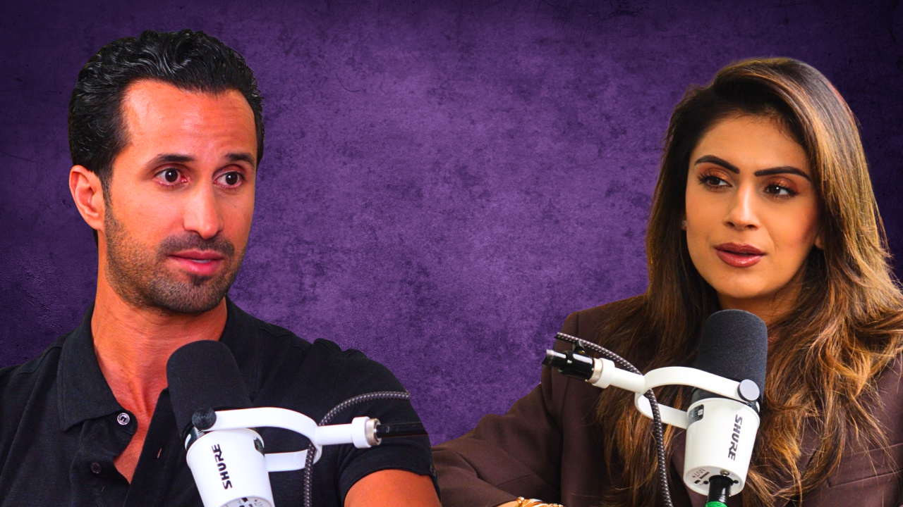 A man and woman seated at microphones during a recording or interview, with a purple textured background.