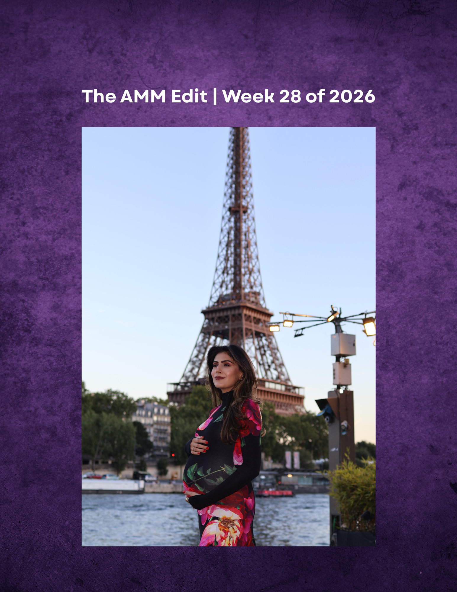 A woman in a black and floral dress stands by a river in front of the Eiffel Tower during the evening.