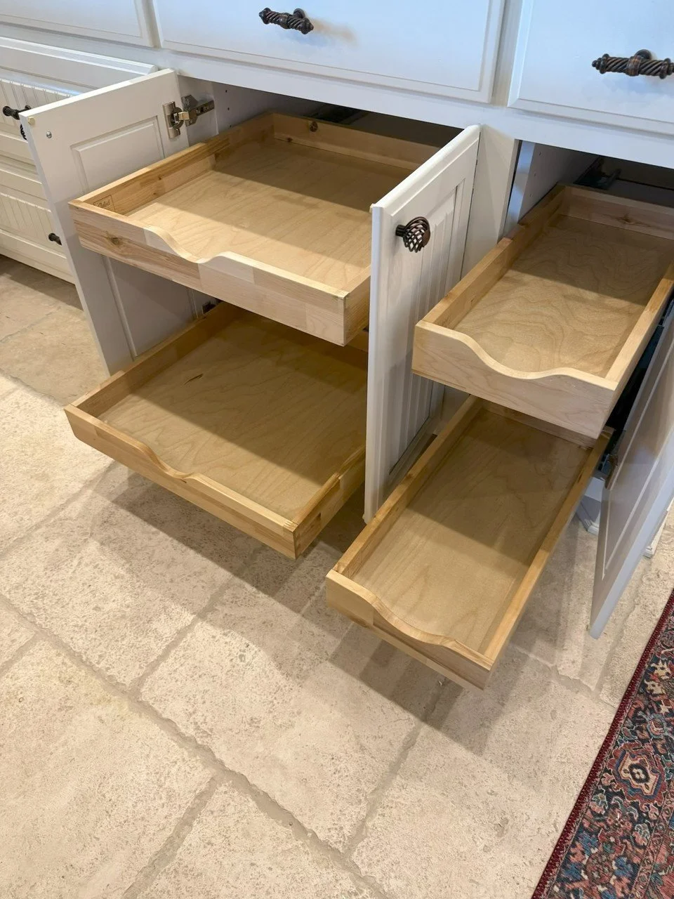 Open kitchen cabinets with empty wooden drawers and shelves.