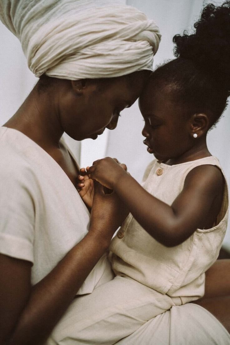Une femme et une jeune fille stabilisent leurs têtes et se tiennent la main dans une posture intime et protectrice.