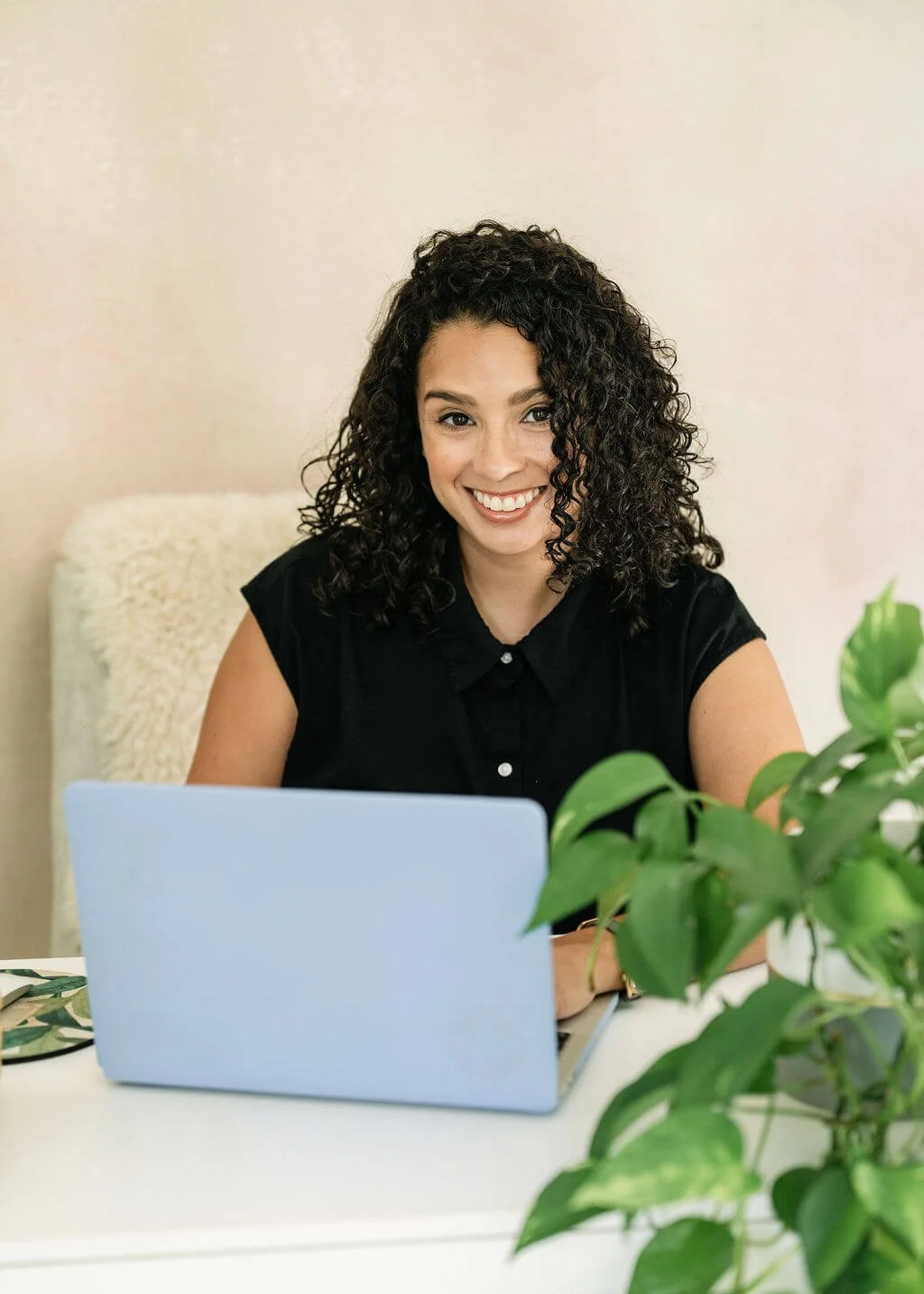 Christina Martin Kenny, nonprofit fundraising consultant, smiling at laptop writing her weekly newsletter, Fresh Pressed.