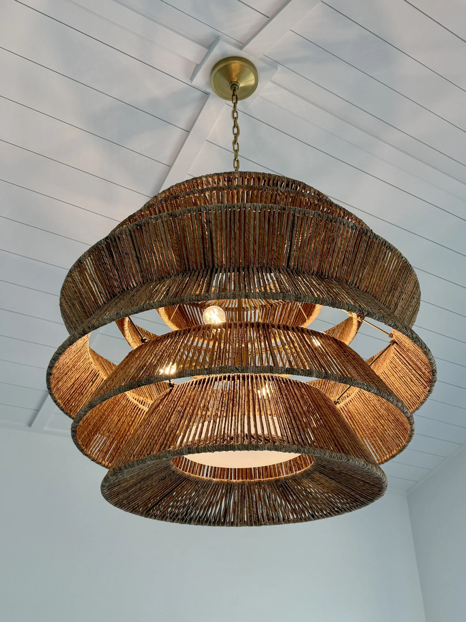 Woven pendant light under a shiplap ceiling