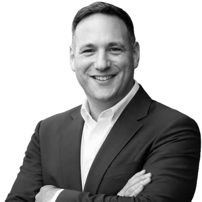 Black and white portrait of a smiling man in a suit with crossed arms.