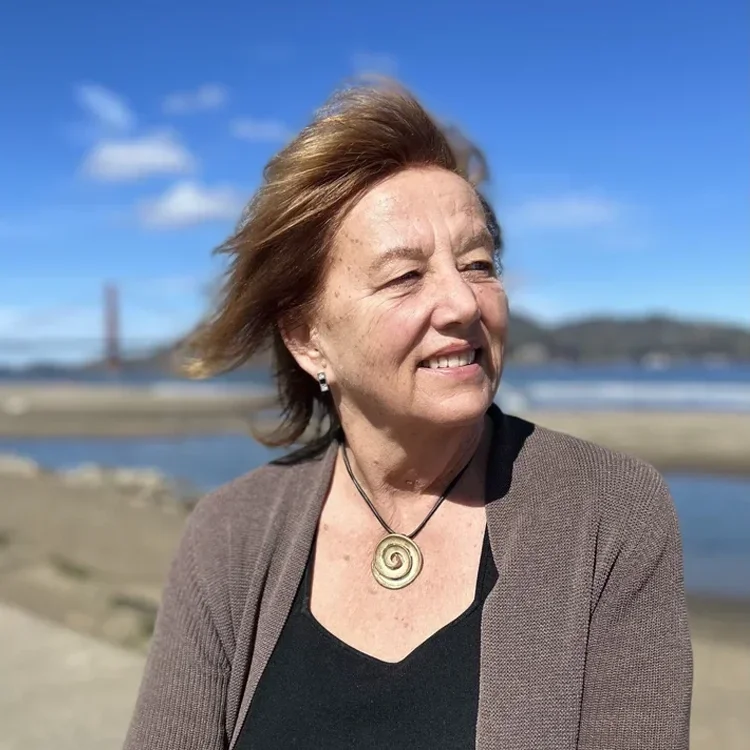 Dr. Kristina Woolsey standing outdoors near the water with the Golden Gate Bridge in the background