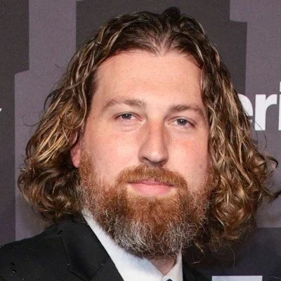 Xander Peterson in a black suit against a dark background