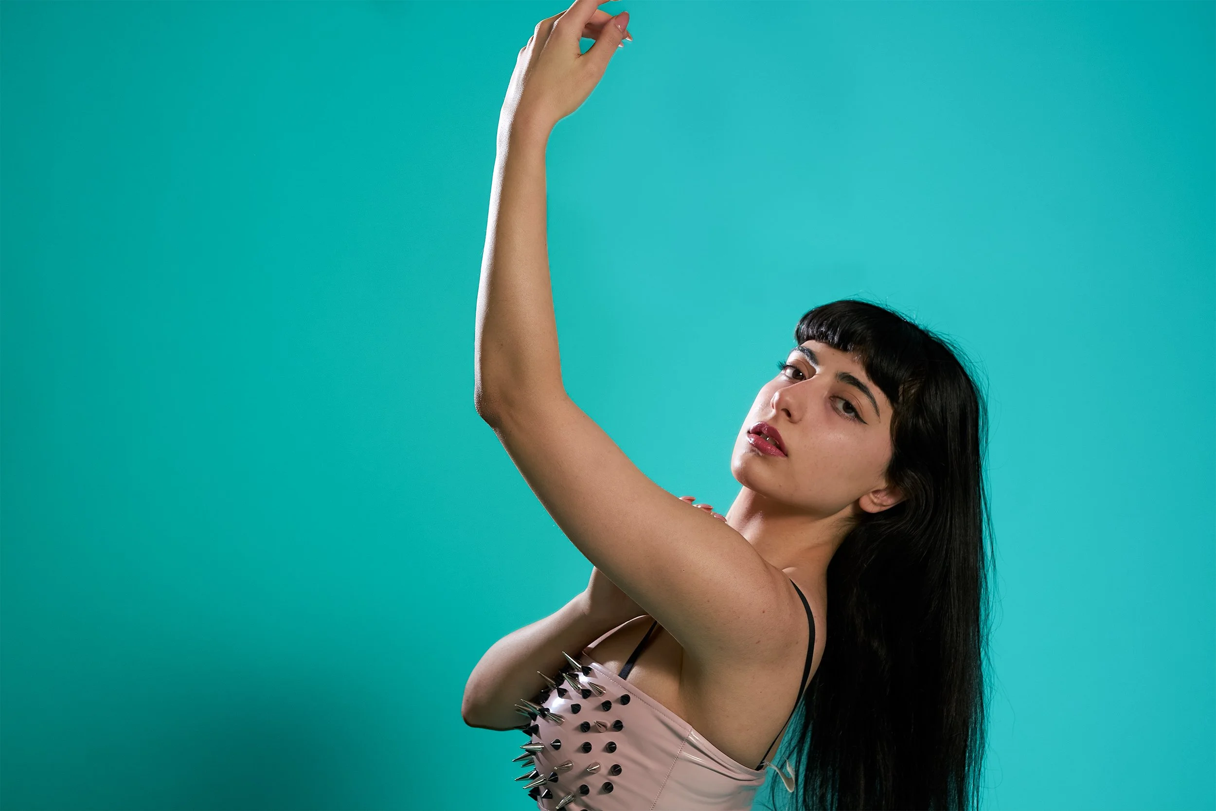 studio photo on blue background, left arm extended 