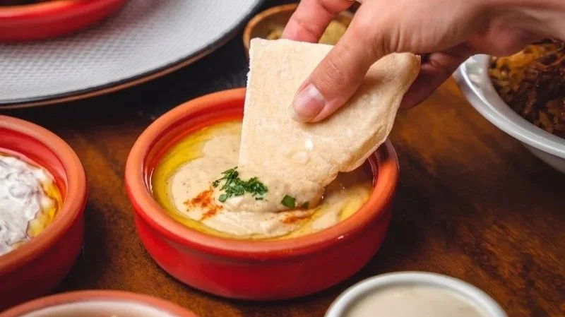 Plato tradicional de hummus casero con aceite de oliva y pan árabe en restaurante Baalbek Quito.