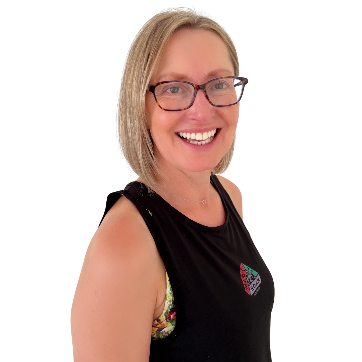 A woman with shoulder-length blonde hair, glasses, and a black tank top, smiling at the camera.