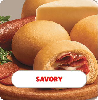 Cheese, cured meats, and a stuffed bread roll on a wooden platter with a label reading 'Savory'.