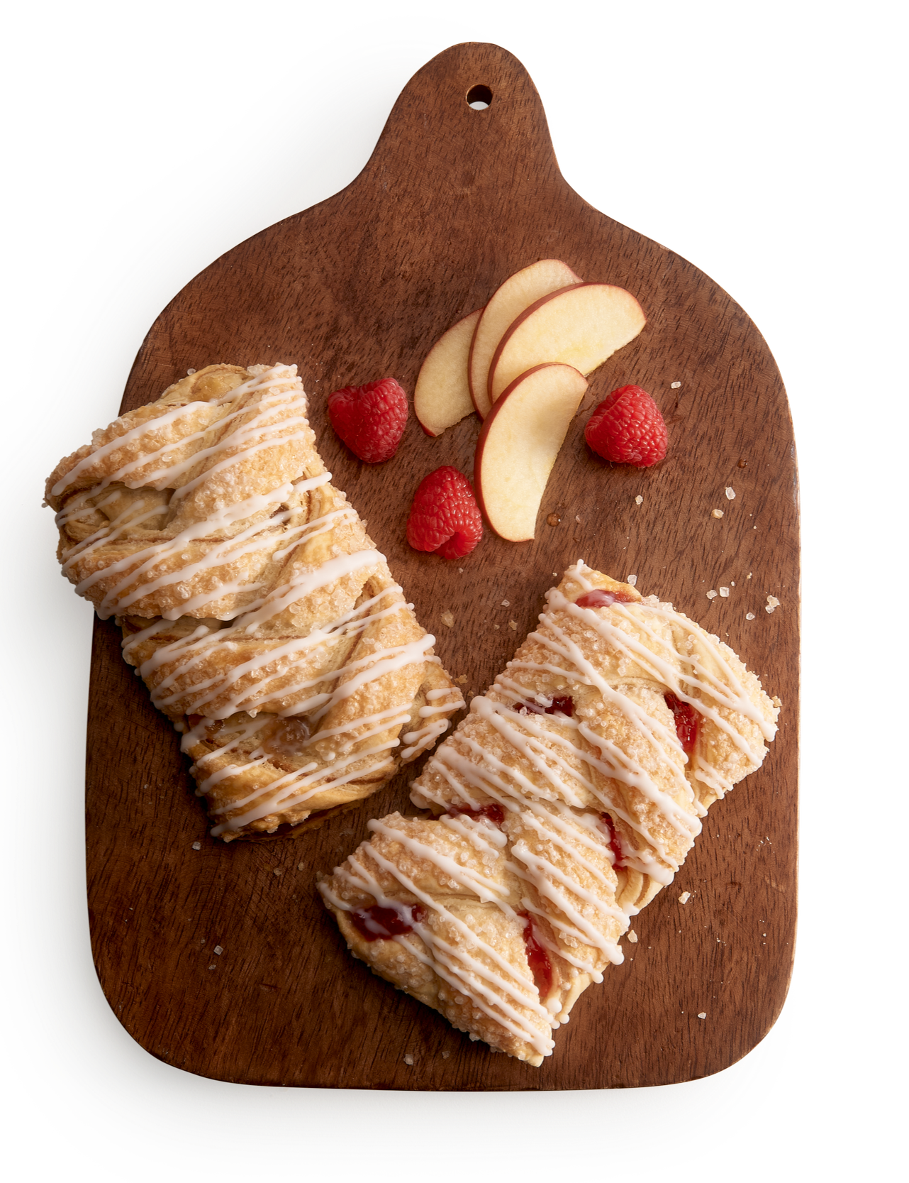 Wooden tray with two strudels and raspberries and apple slices beside them.