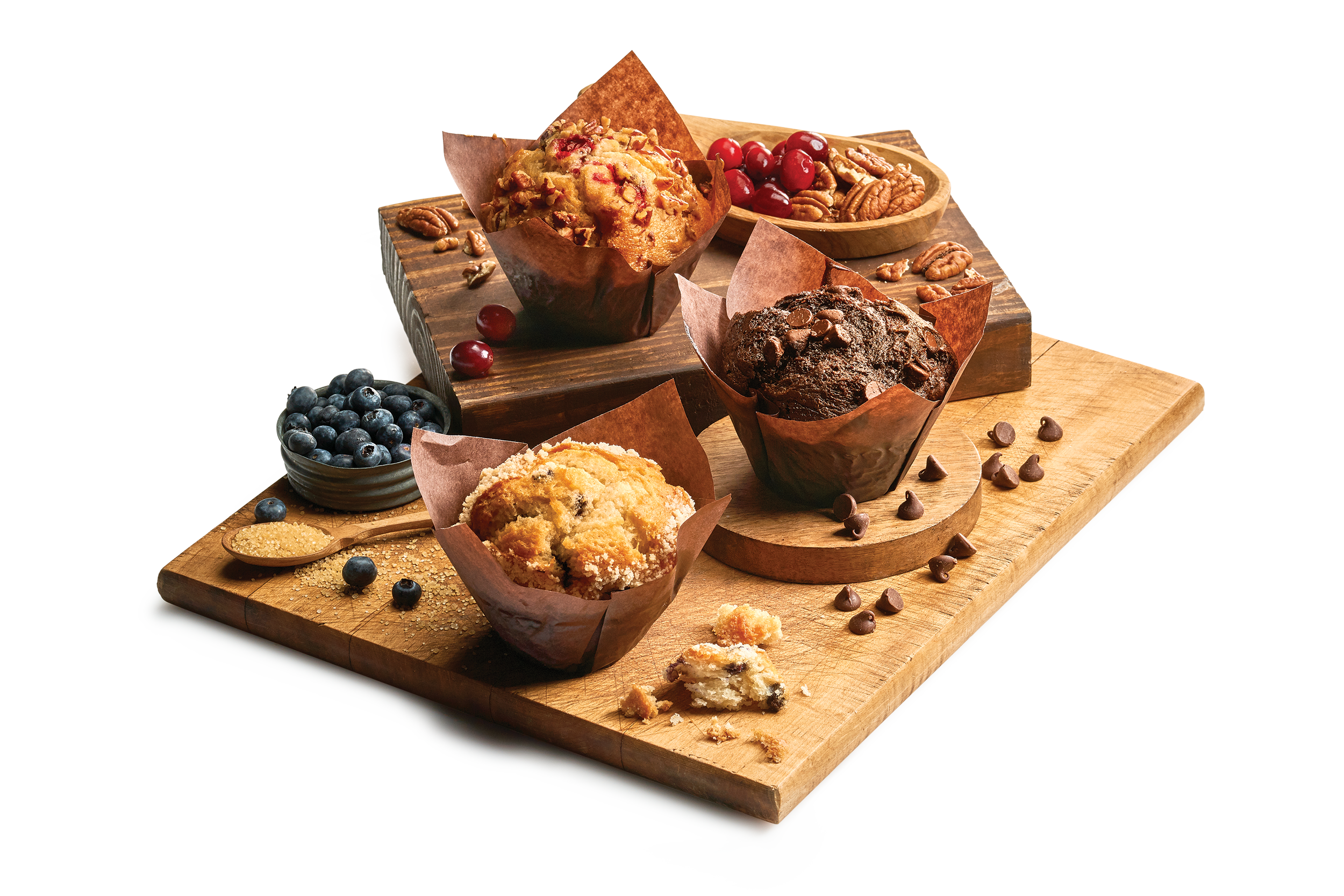 Tray with a variety of muffins and fruit, nuts and chocolate chips sprinkled on the tray.