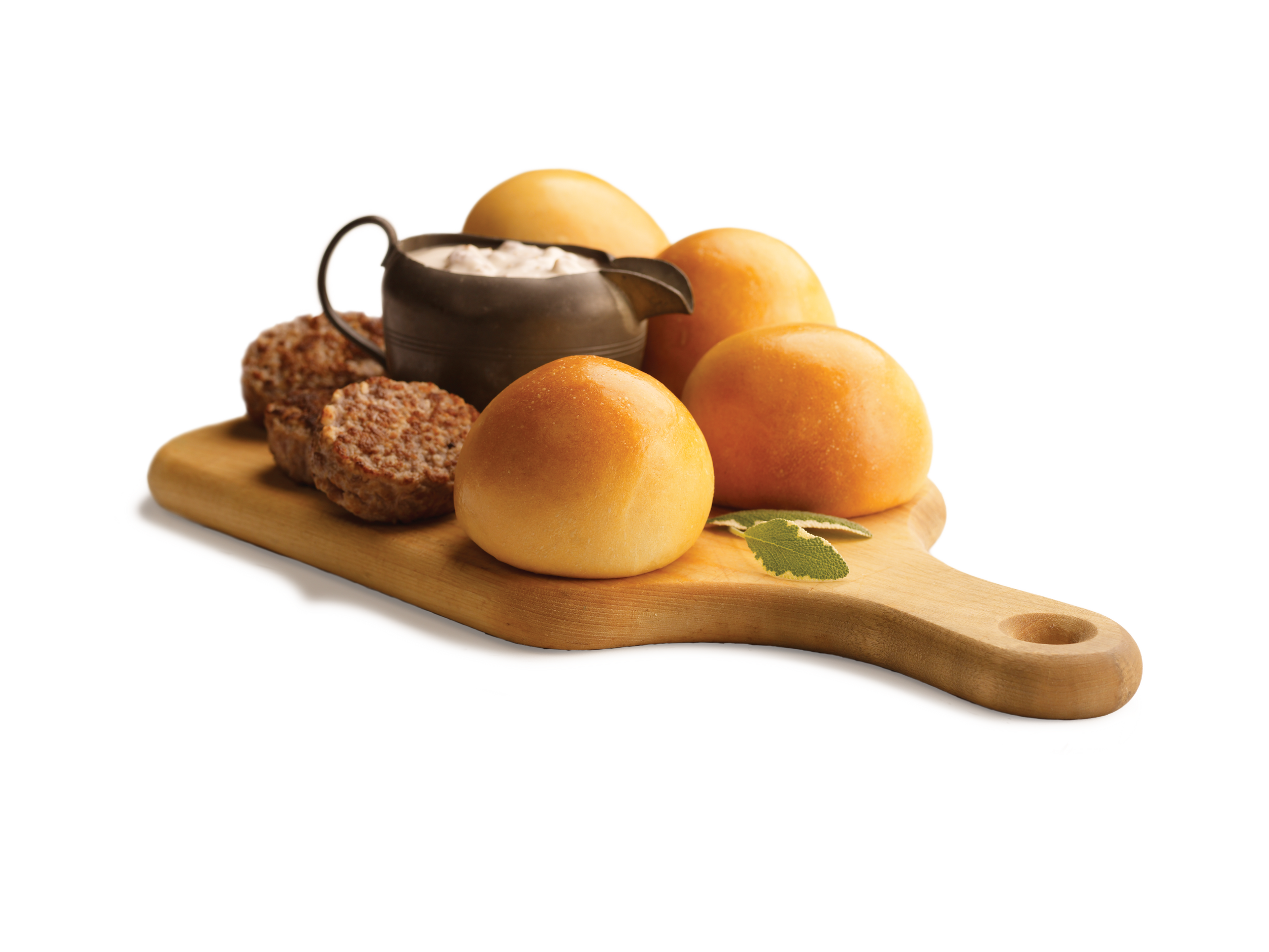 Four kolaches on a wooden board with sausage and a pot of gravy.