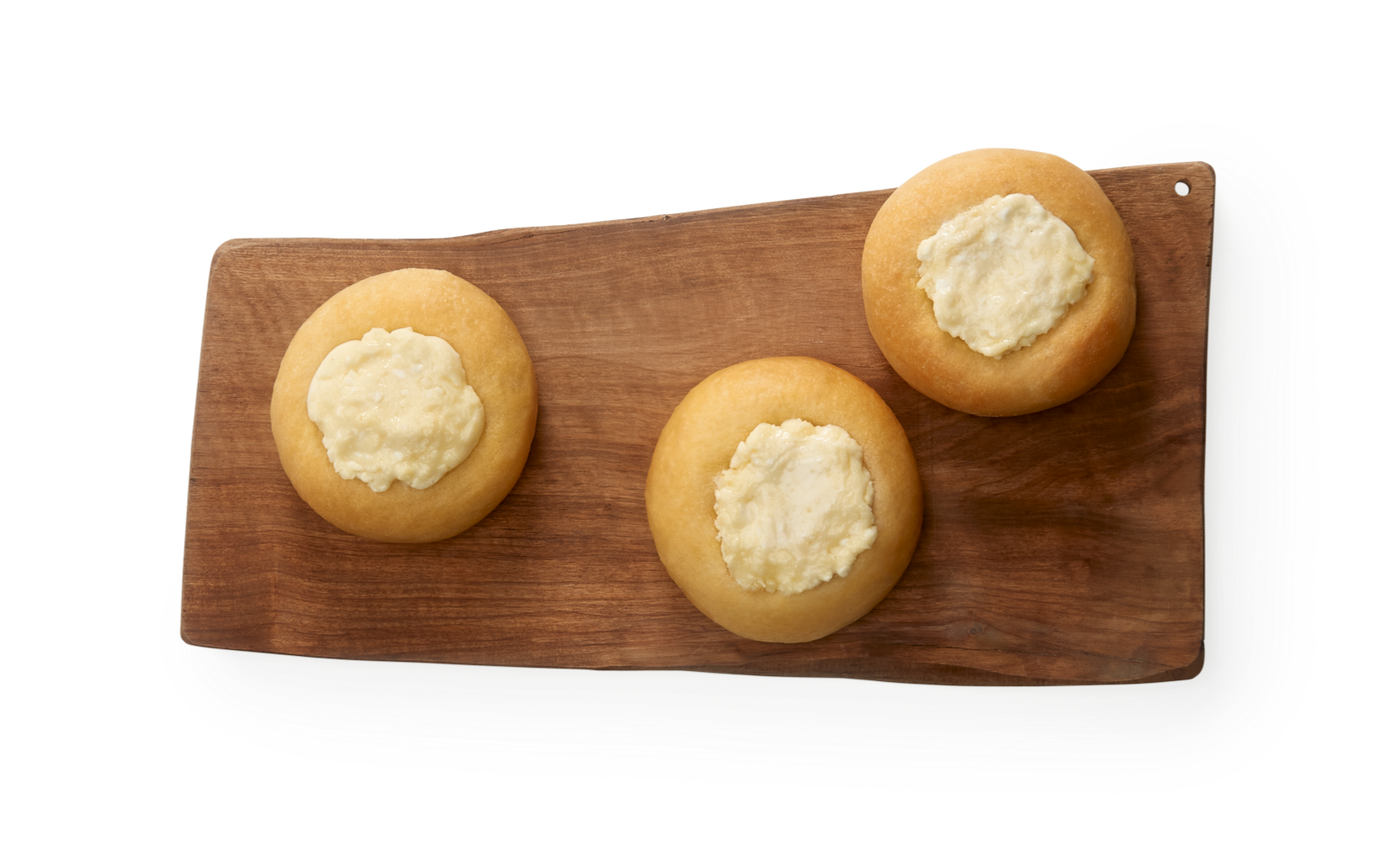 Three Kolaches filled with cream cheese on a wooden serving platter.