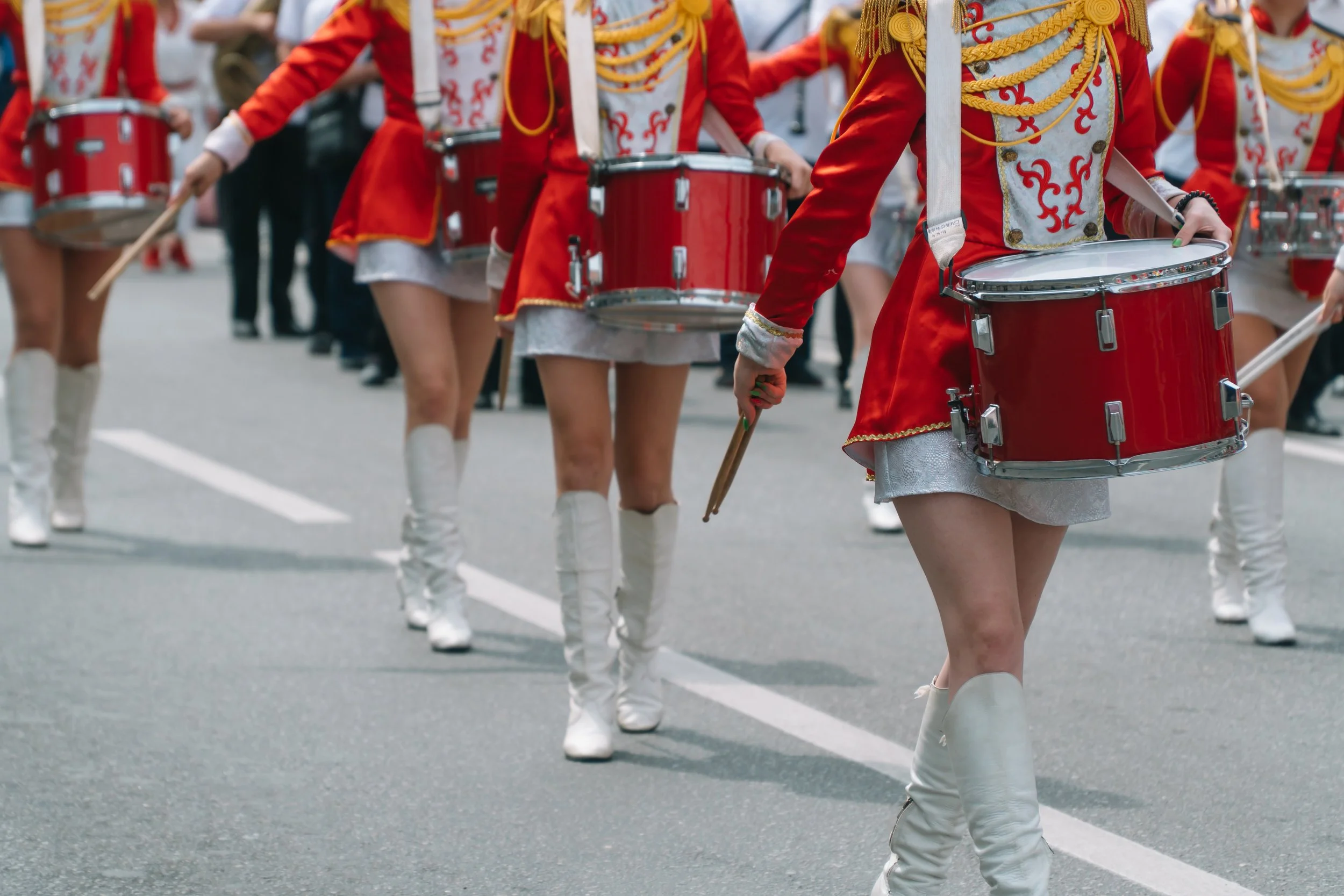 Groupe de musiciens en uniforme de carnaval jouant de la batterie dans une parade en extérieur.