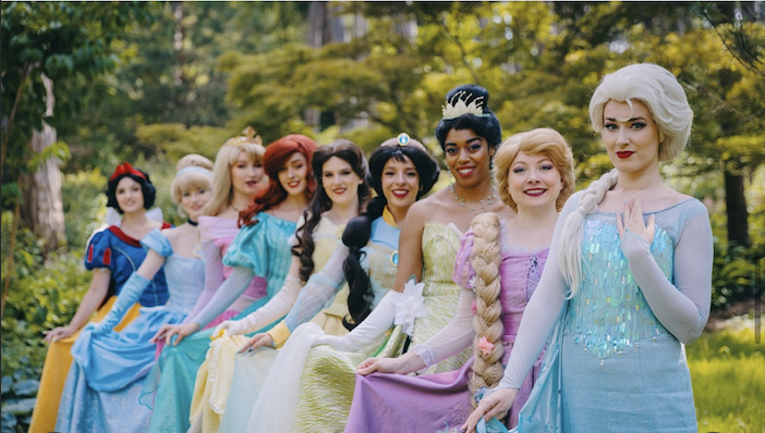 Groupe de princesses de Disney comme Blanche-Neige, Cendrillon, Ariel, et Elsa dans un décor naturel en forêt.