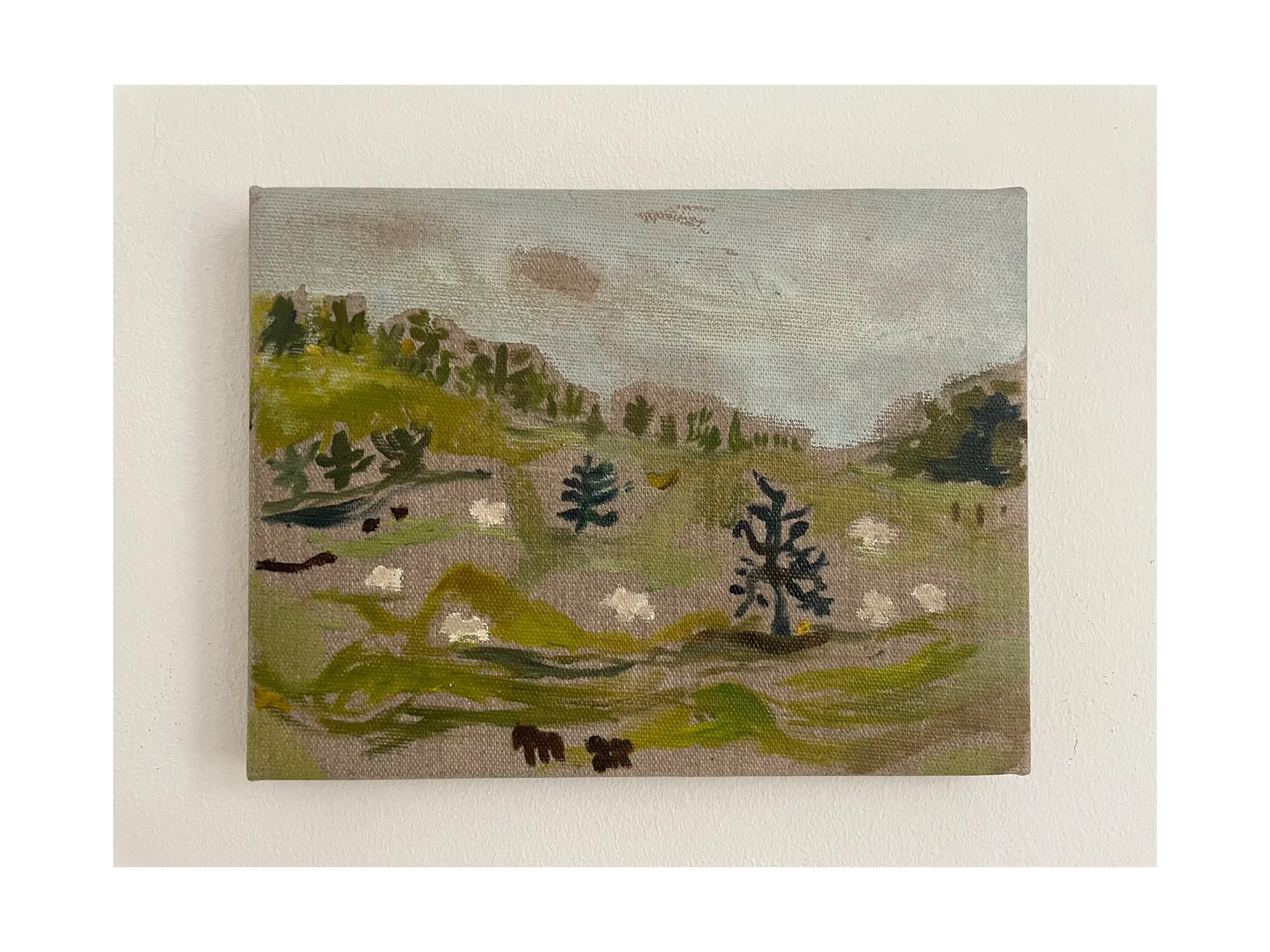 A small landscape painting on canvas depicting rolling green hills, trees, and a cloudy sky.