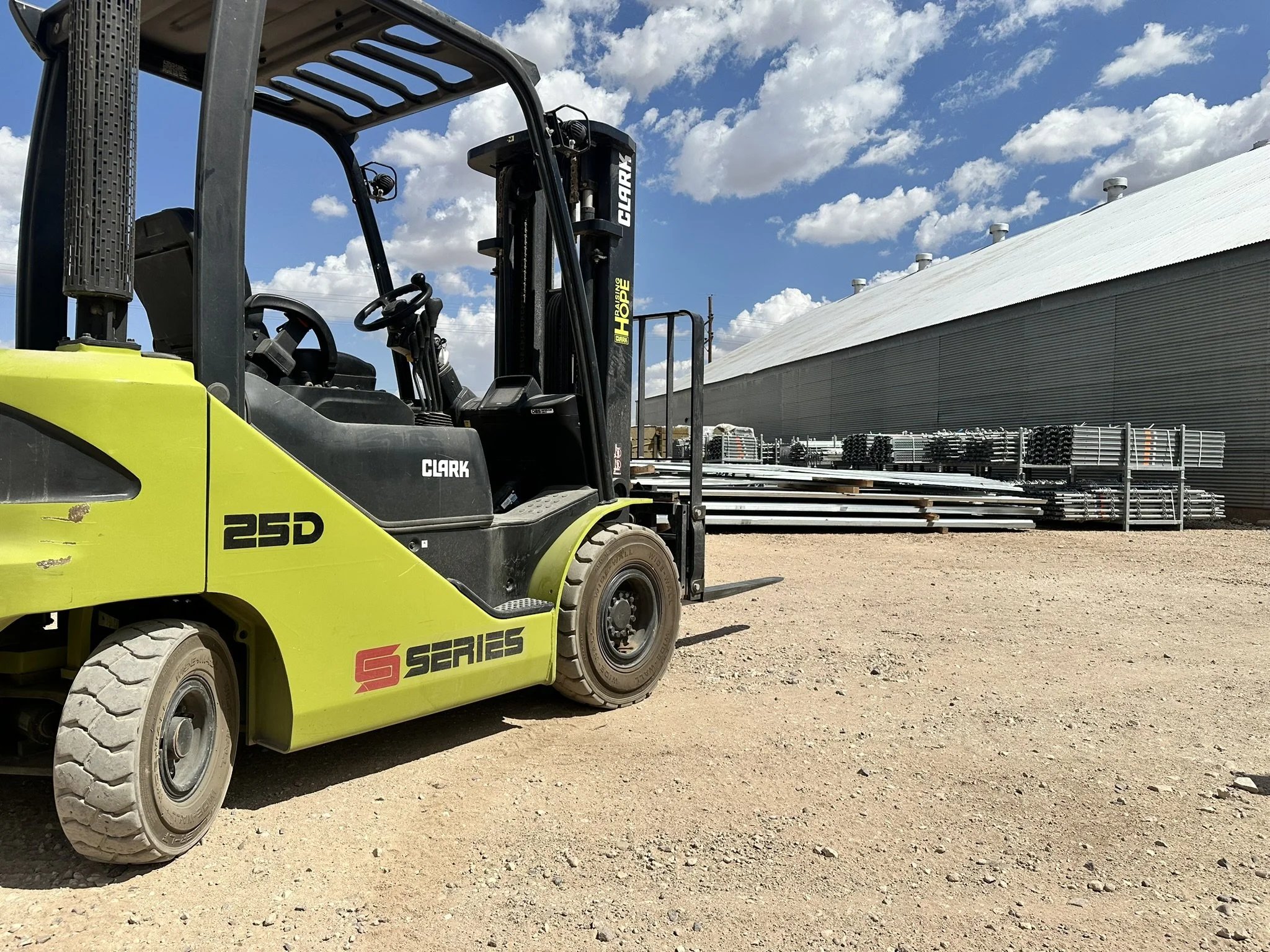 Forklift in foreground with outdoor storage space for lease