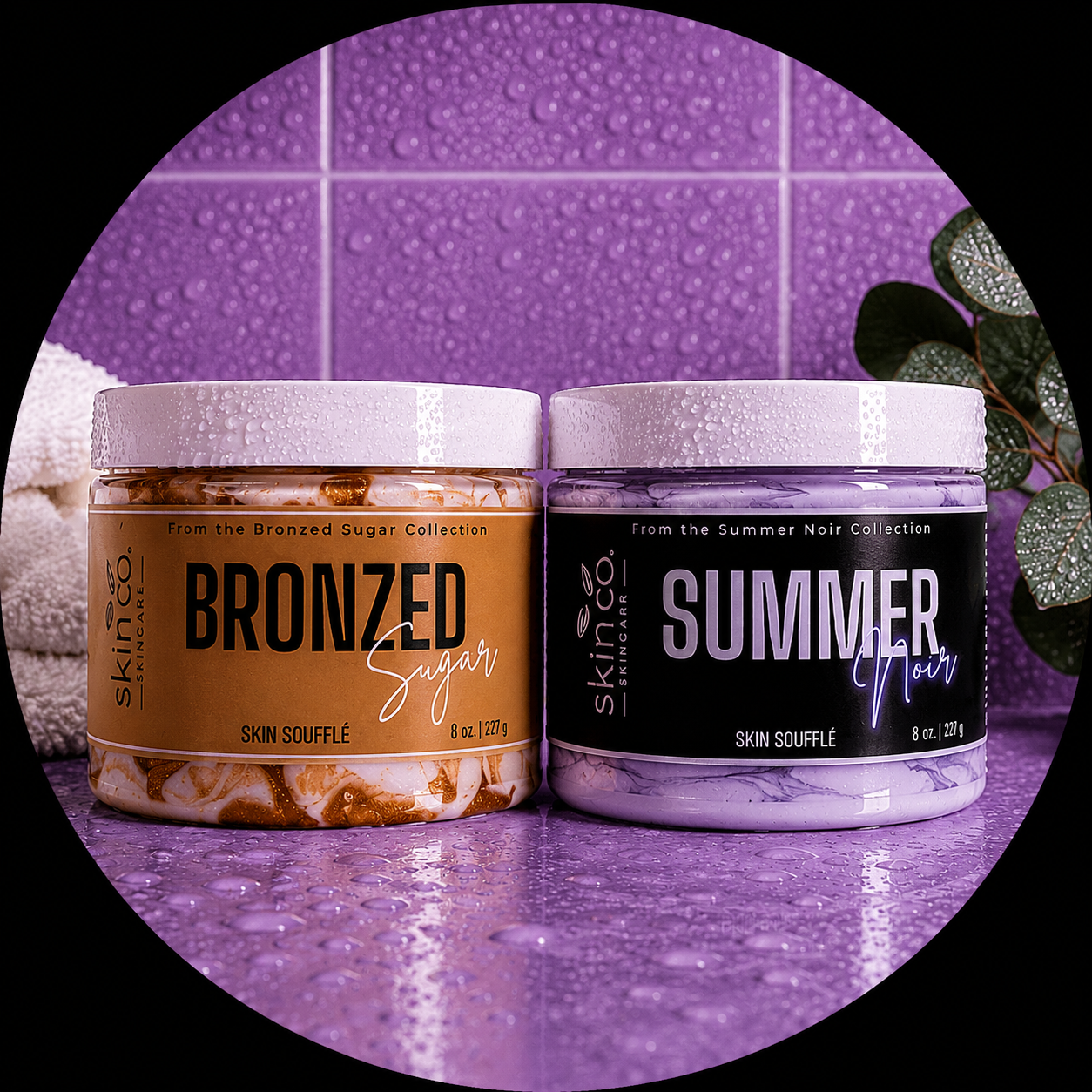 Two jars of skincare products labeled 'Bronzed Sugar' and 'Summer Noir,' placed on a purple tiled surface with water droplets on the jars and purple tiles in the background, along with a leafy plant on the right side.