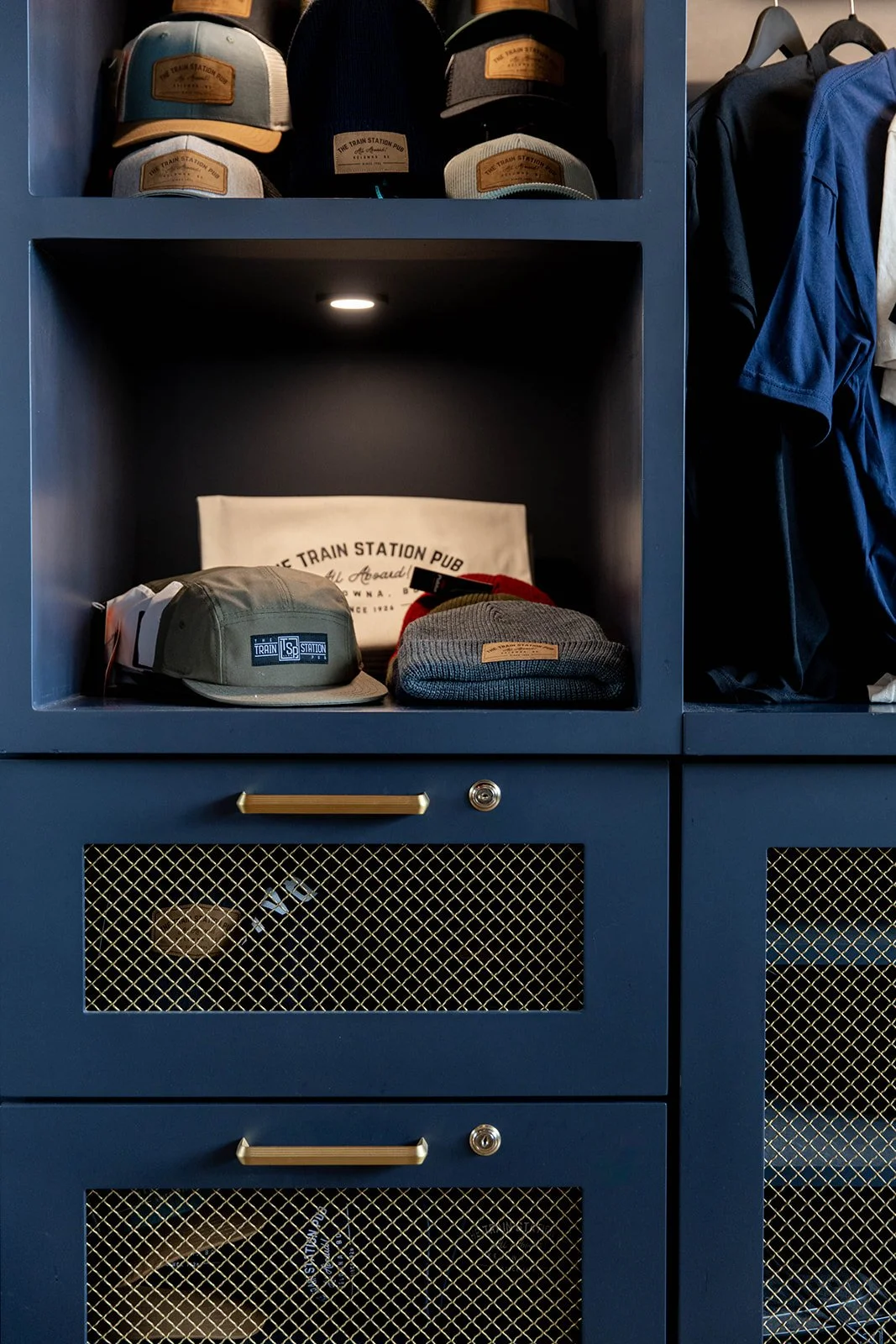Merchandize locker at The Train Station Pub with caps and hats on the top shelf to purchase
