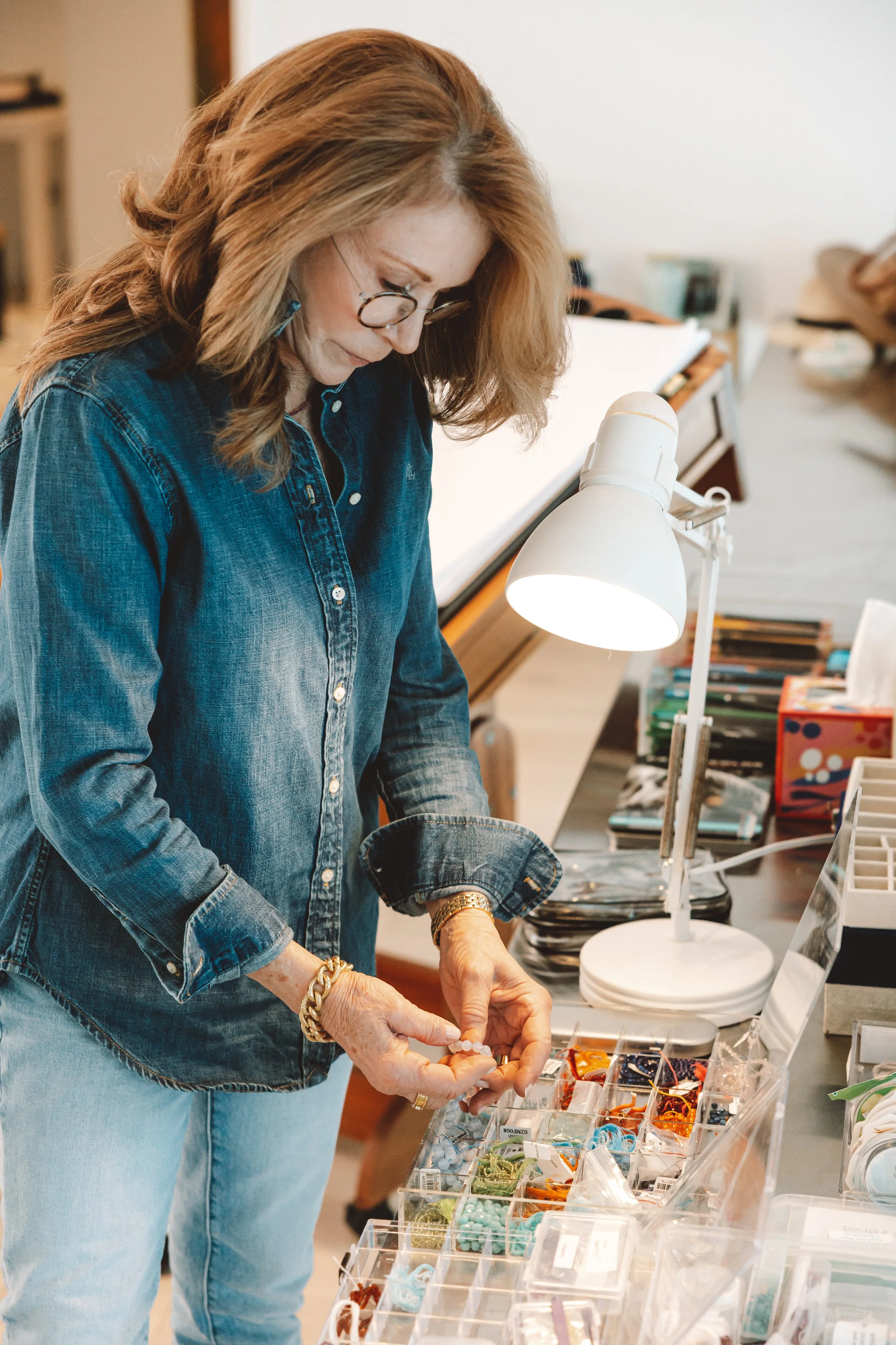 A woman creating timeline jewelry at her studio.