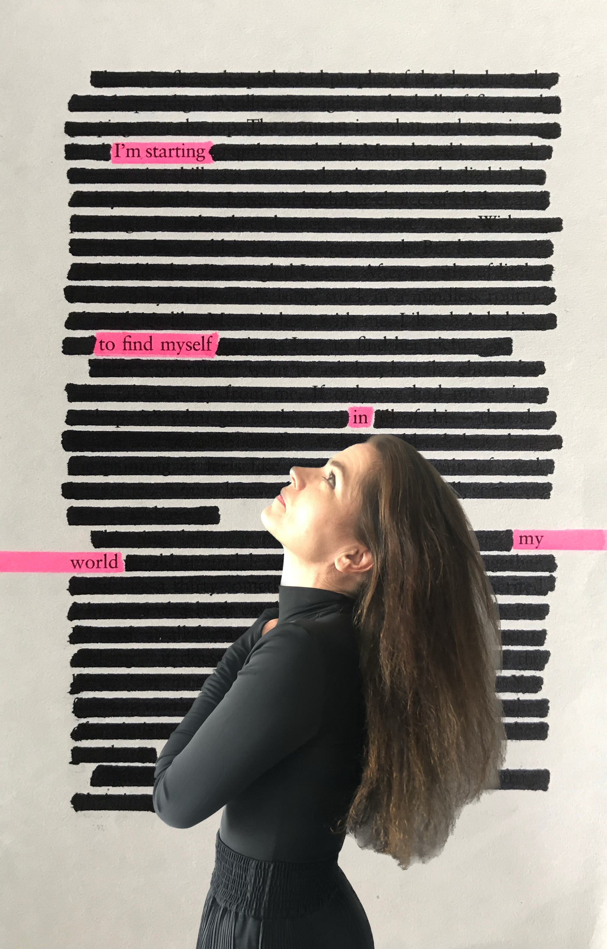 A woman with long brown hair wearing a black long sleeve top and black pants standing with arms crossed against a black and white striped wall with pink highlighted text reading, "I'm starting to find myself in my world."