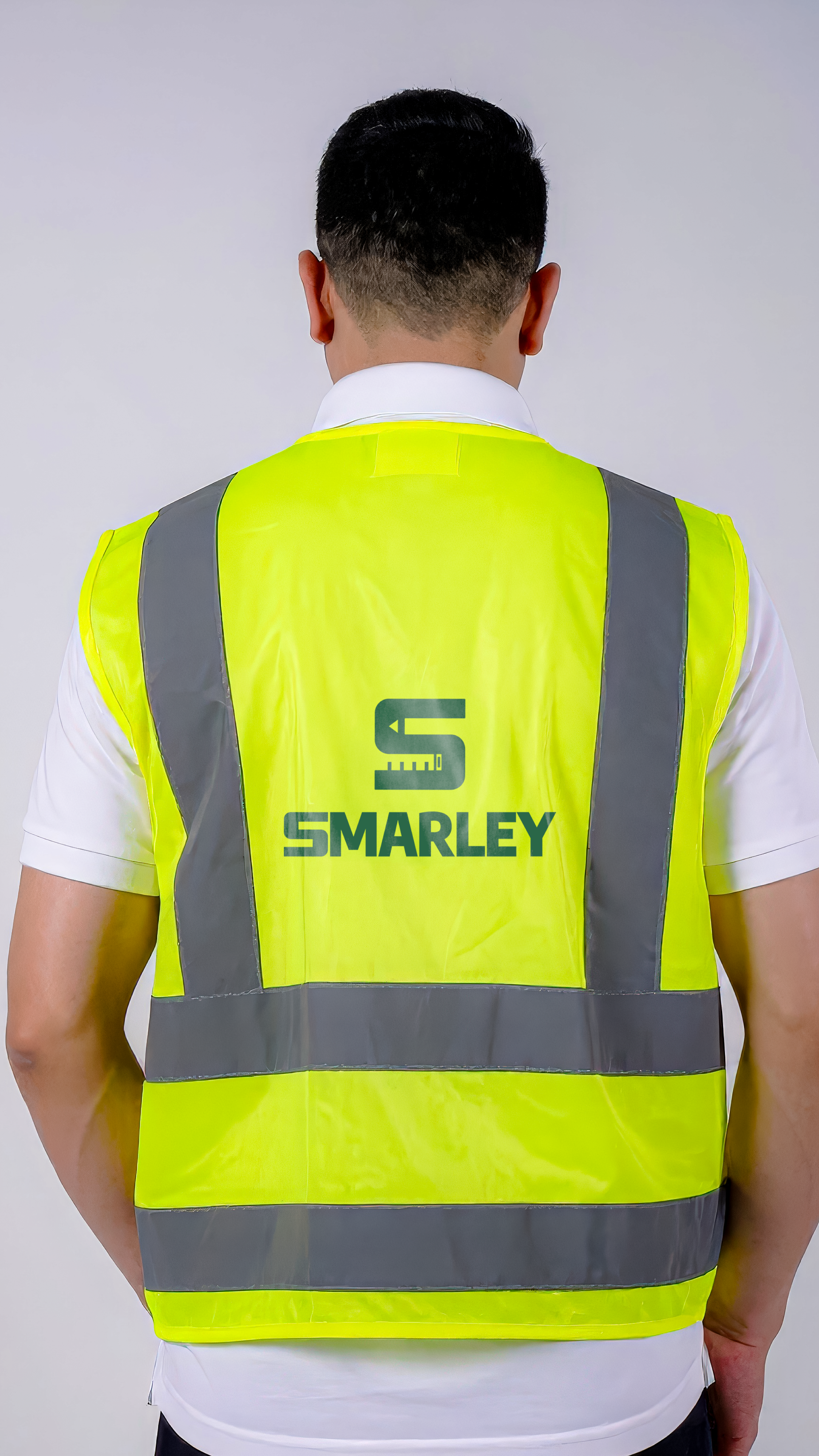 Person wearing a yellow safety vest with reflective stripes and the name 'Smarley' on the back, facing away from the camera.