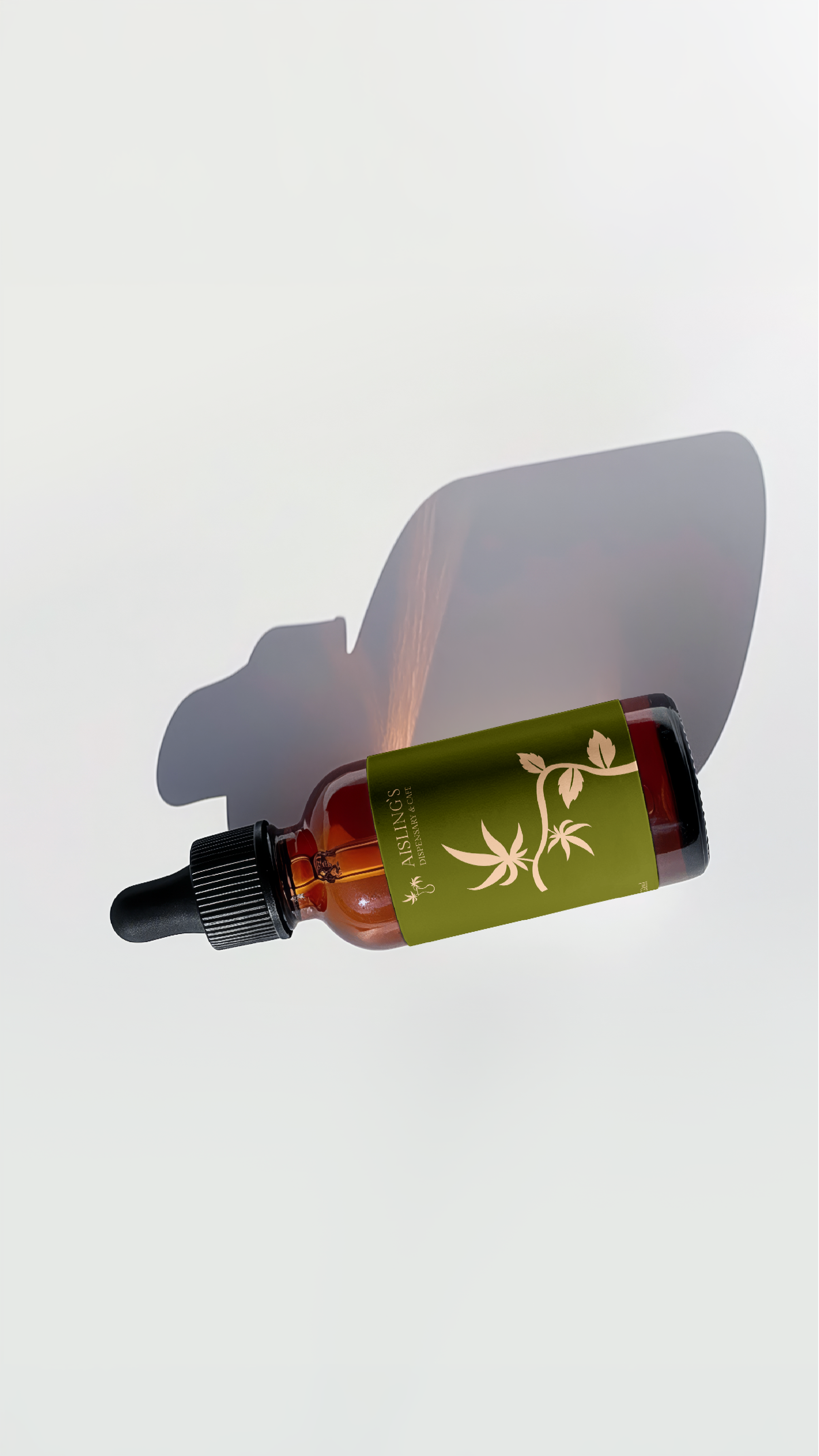 A small brown glass dropper bottle with a dark green cap and a green label featuring a white leaf design and the text 'Aisling's Dispensary'.