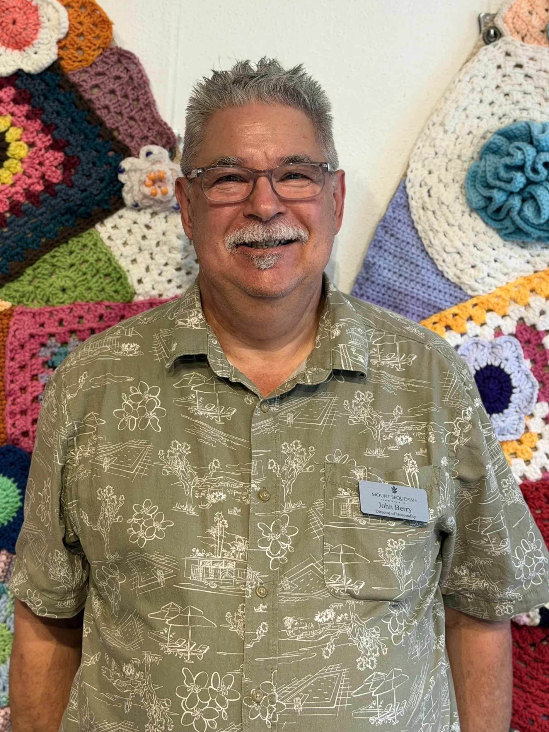Man in patterned shirt smiling