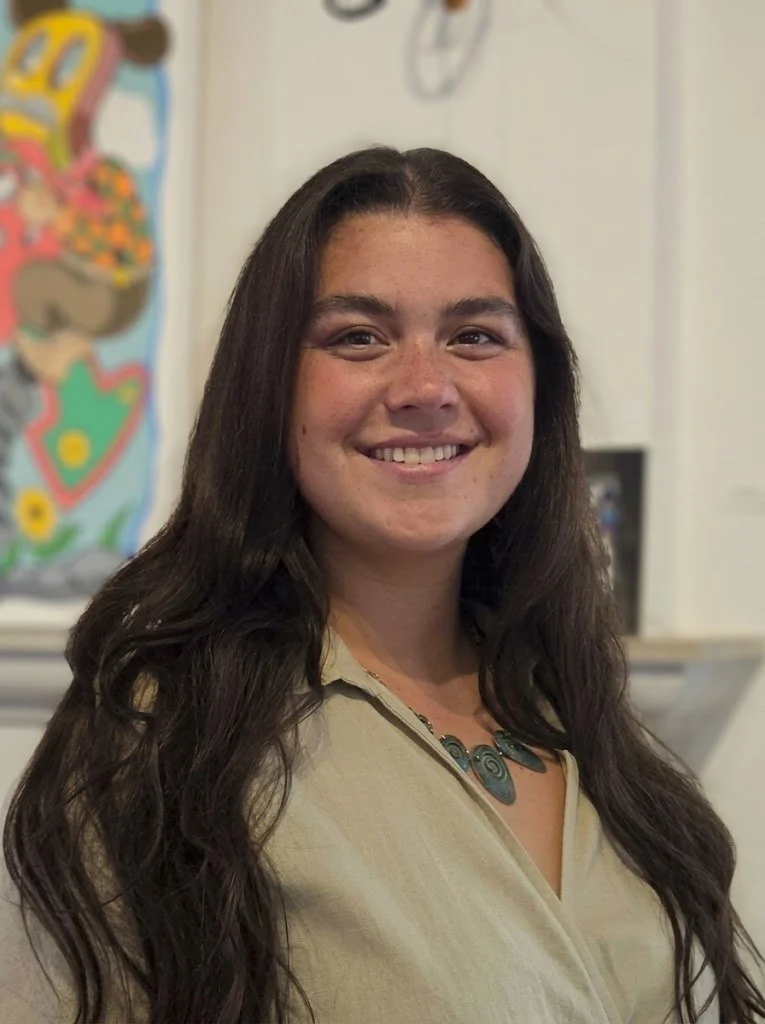 Woman in gray shirt standing and smiling