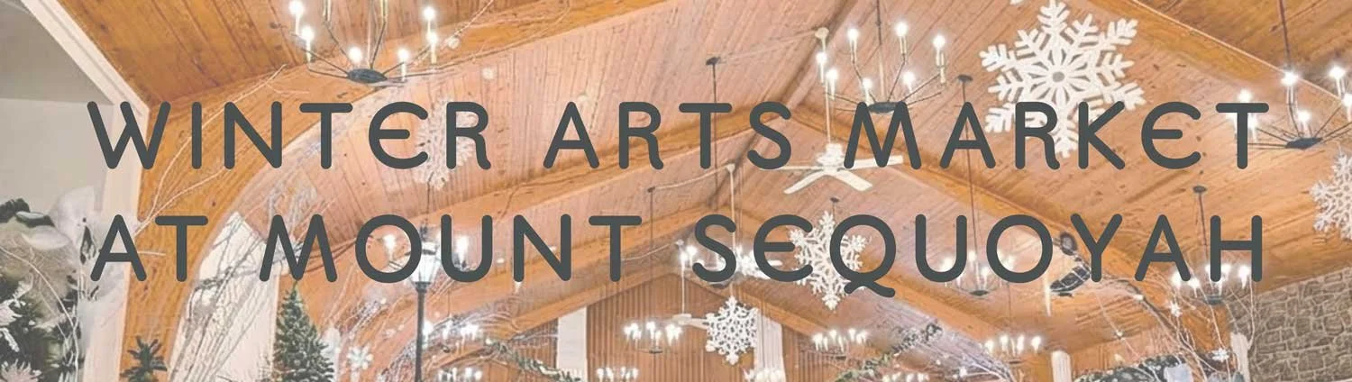 Decorated indoor space for the Winter Arts Market at Mount Sequoyah, featuring snowflake ornaments, string lights, and a wooden ceiling.