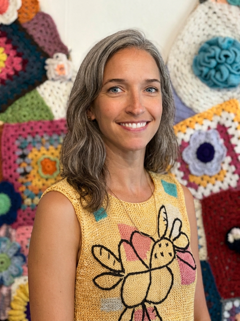 Woman in patterned yellow shirt smiling