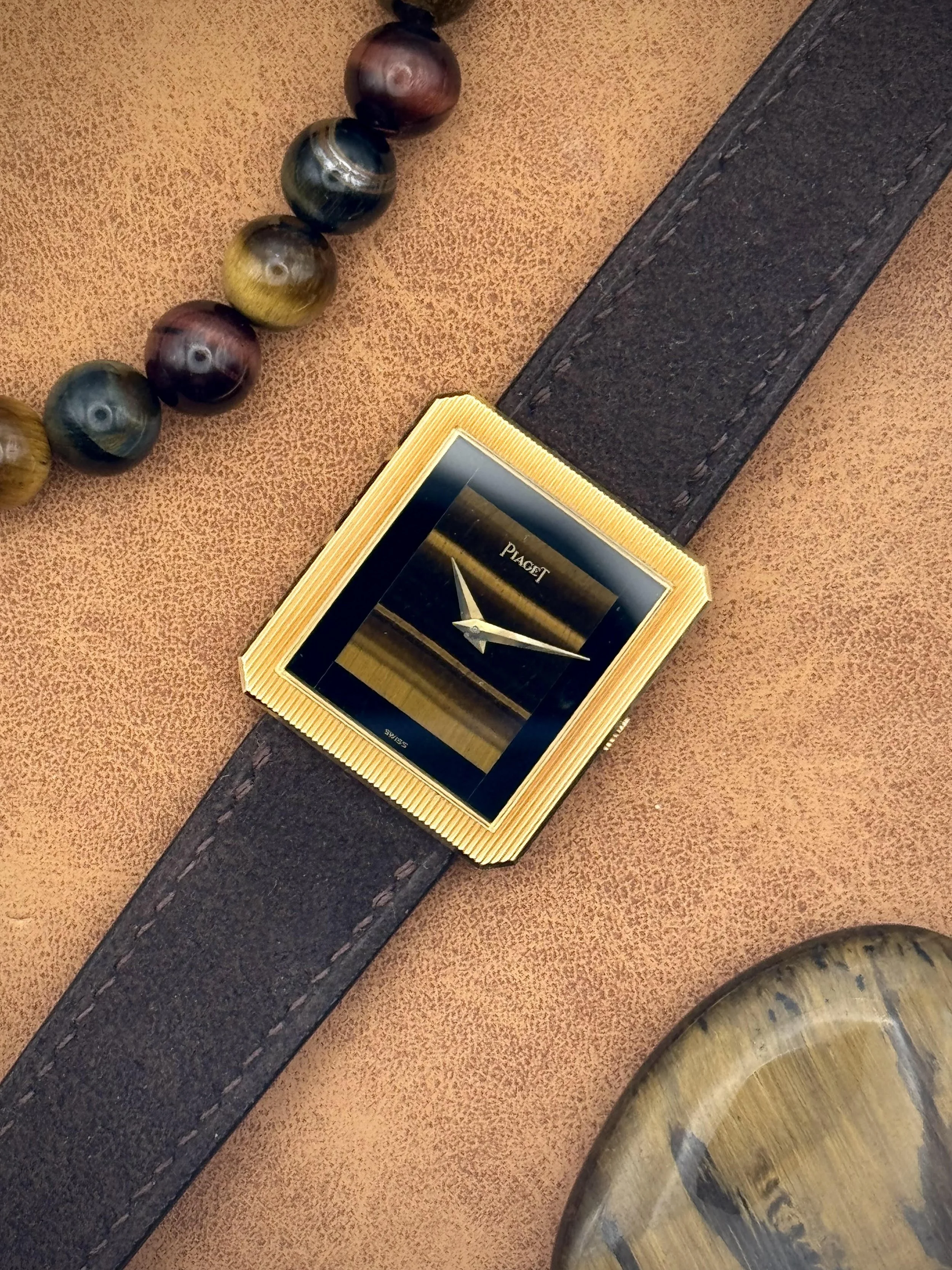 A vintage Piaget Protocole Reference 9154 in a yellow gold case with a tiger's eye dial.