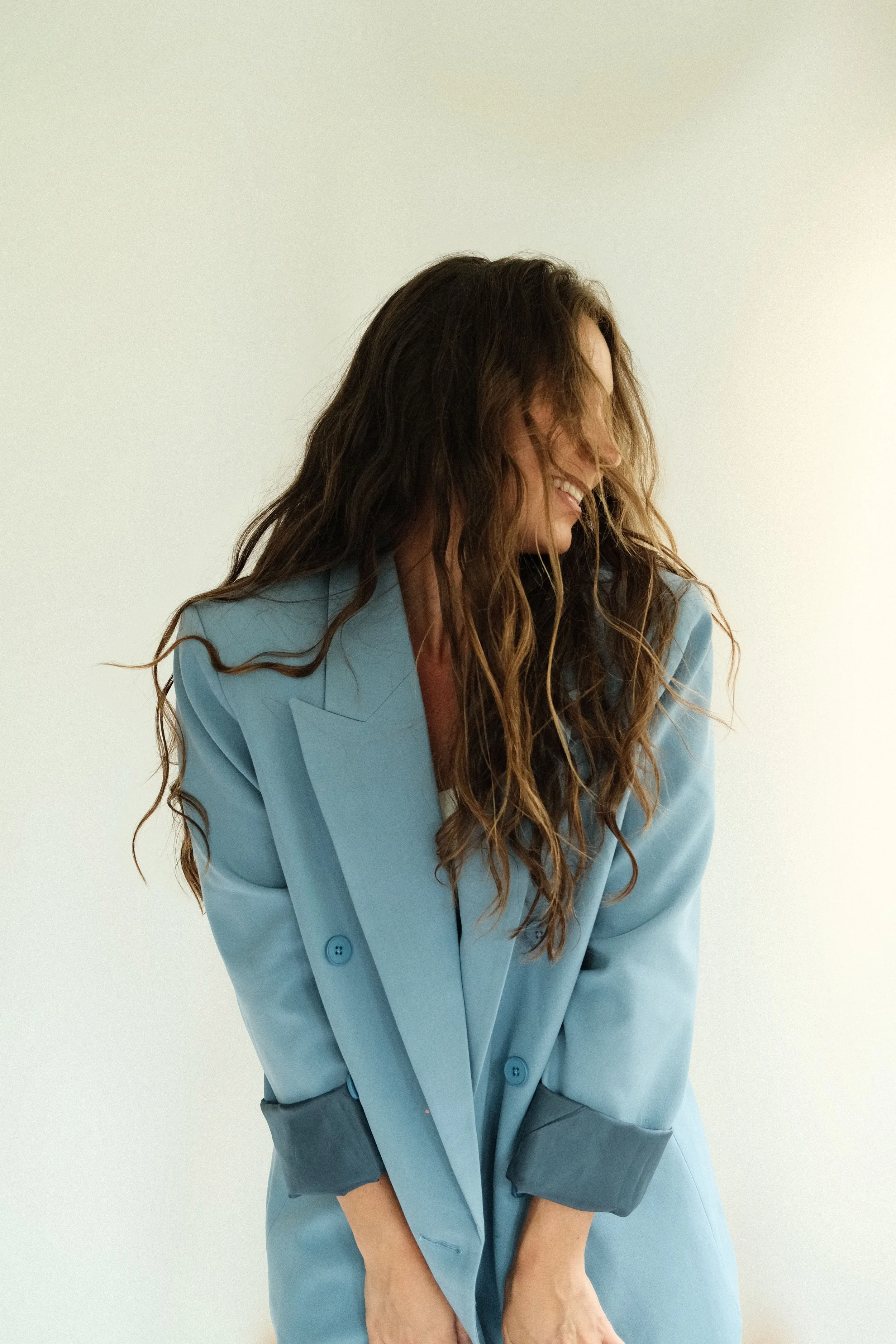 Candid portrait of Kara Lyons, founder and interior designer of Chapter V, wearing a blue blazer