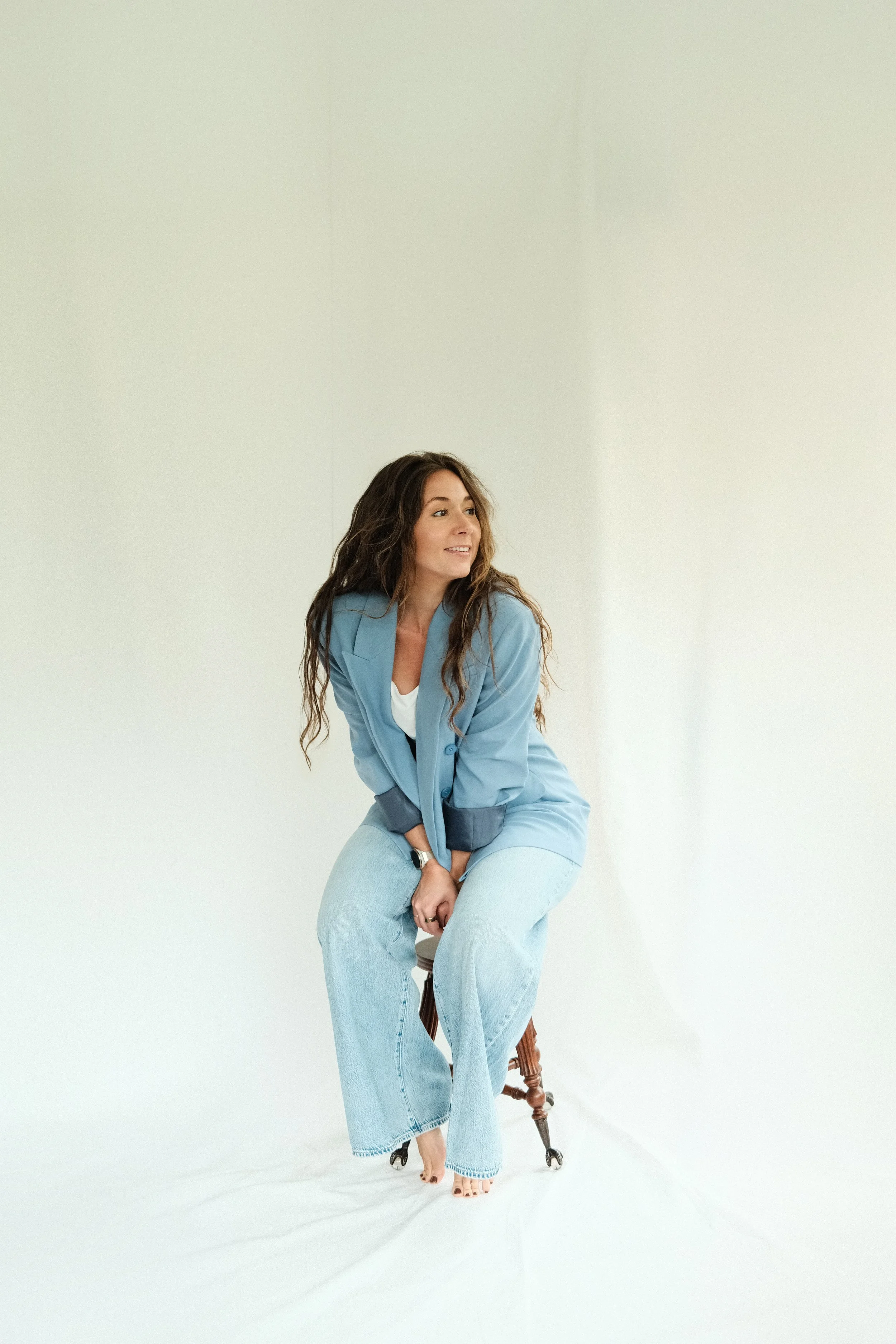 Candid portrait of Kara Lyons, founder and interior designer of Chapter V, wearing a blue blazer