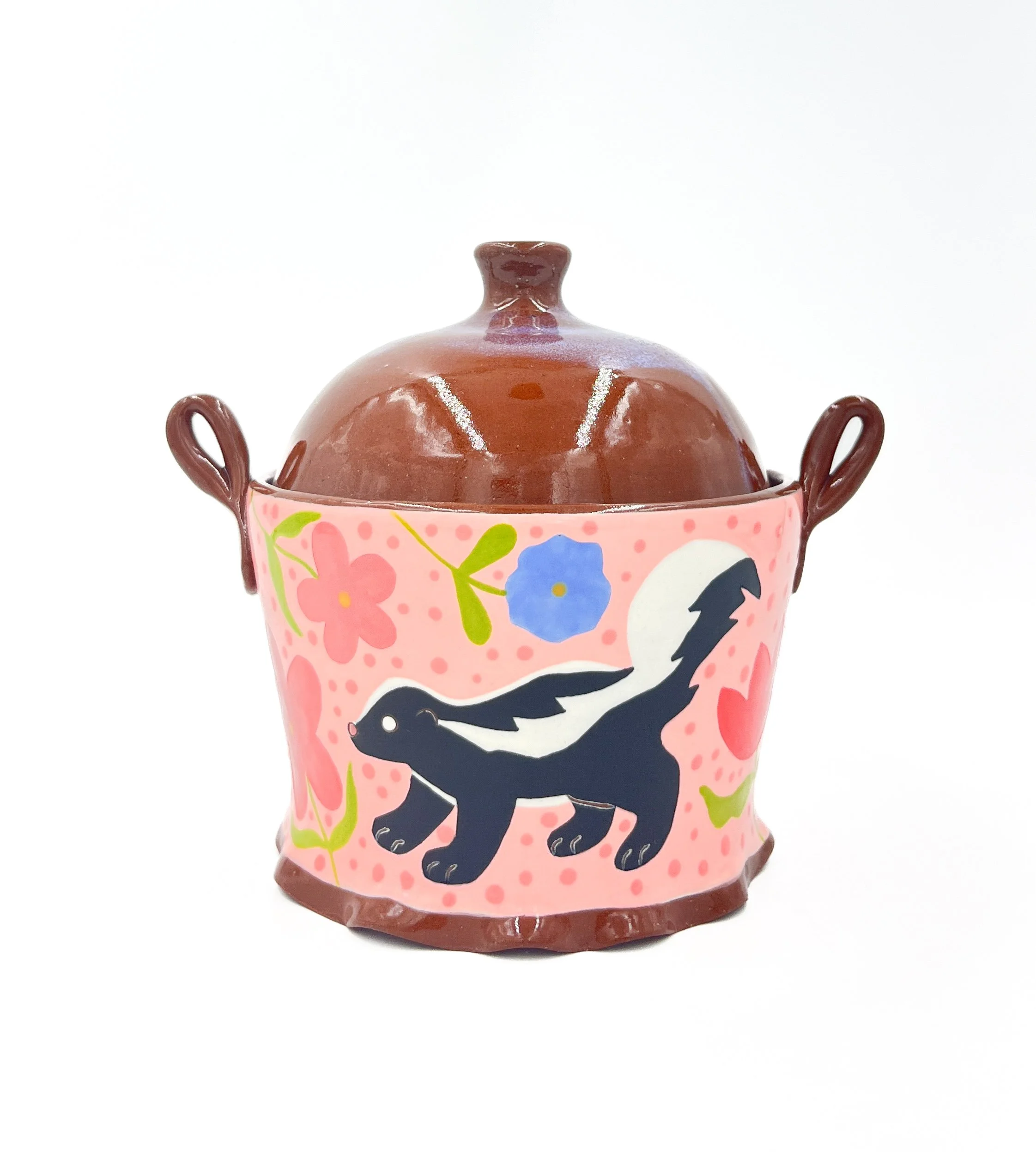 Decorative ceramic sugar bowl with a brown lid, pink body featuring floral and bird design, and two handles on sides.