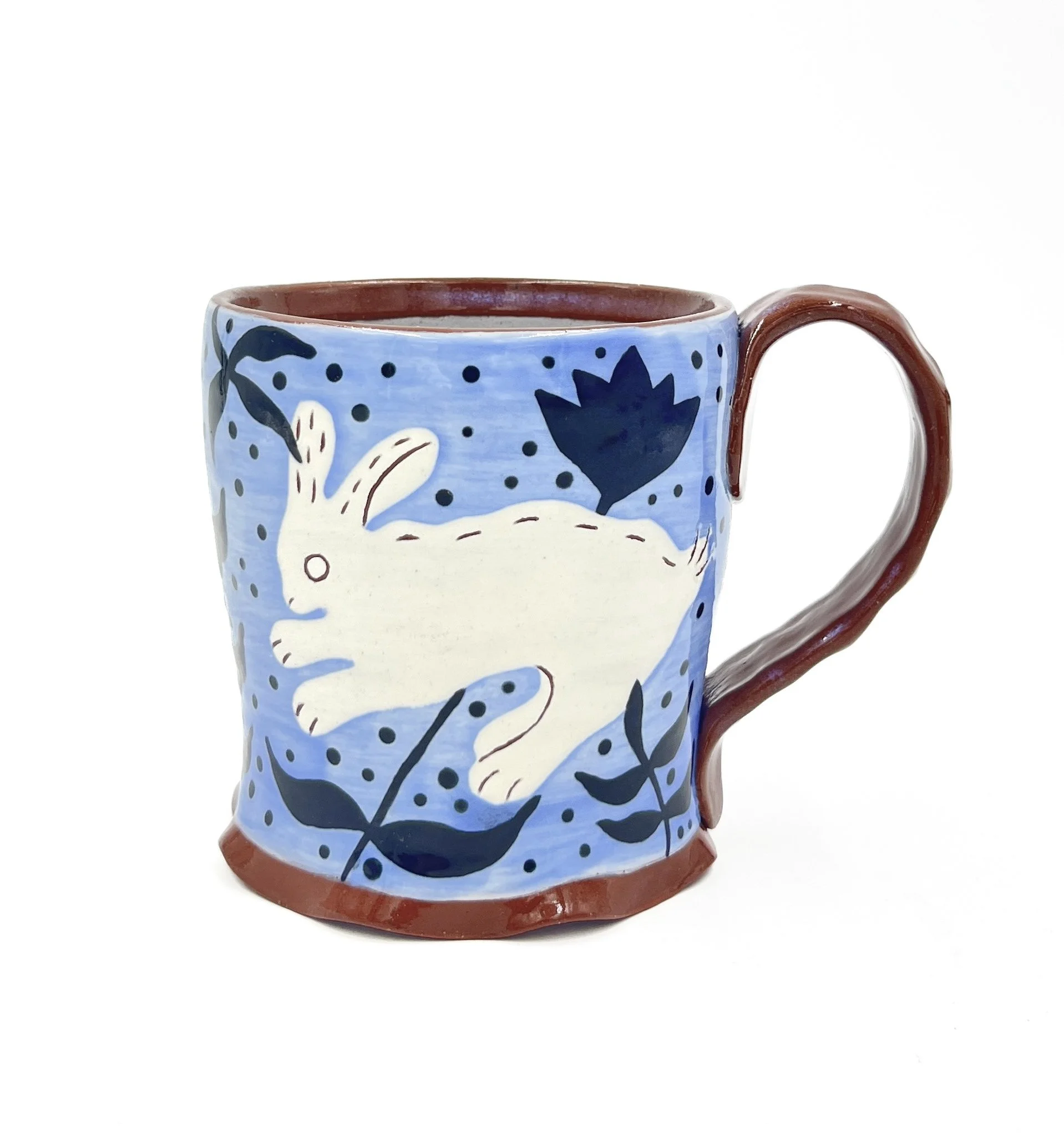 Close-up of a ceramic coffee mug with a colorful hand-painted floral design against a white background.