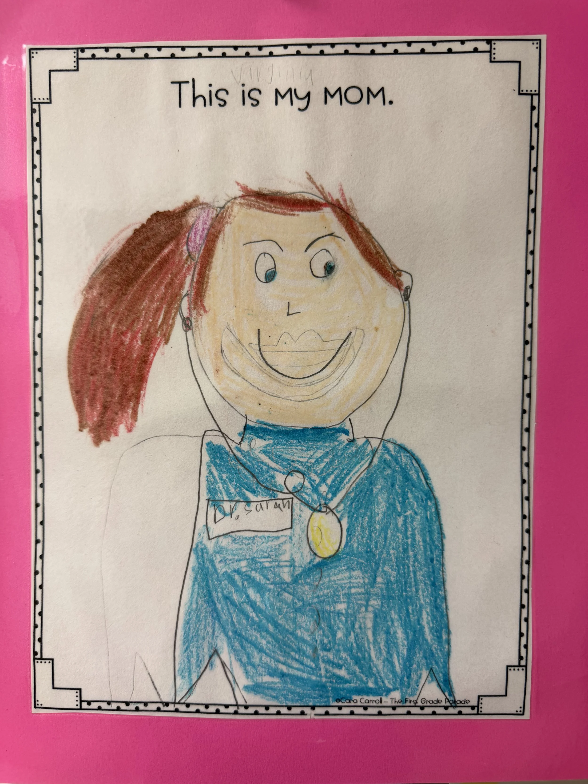 Child's drawing of a smiling woman with brown hair in a ponytail, wearing a blue outfit with a gold necklace, labeled 'Dr. Sarah', framed on a pink background with the text 'This is MY MOM.' at the top.
